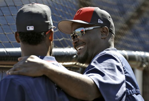 Minnesota Twins hitting coach James Rowson, right, laughs as he talks to center fielder Danny Santana before a spring training baseball game against t