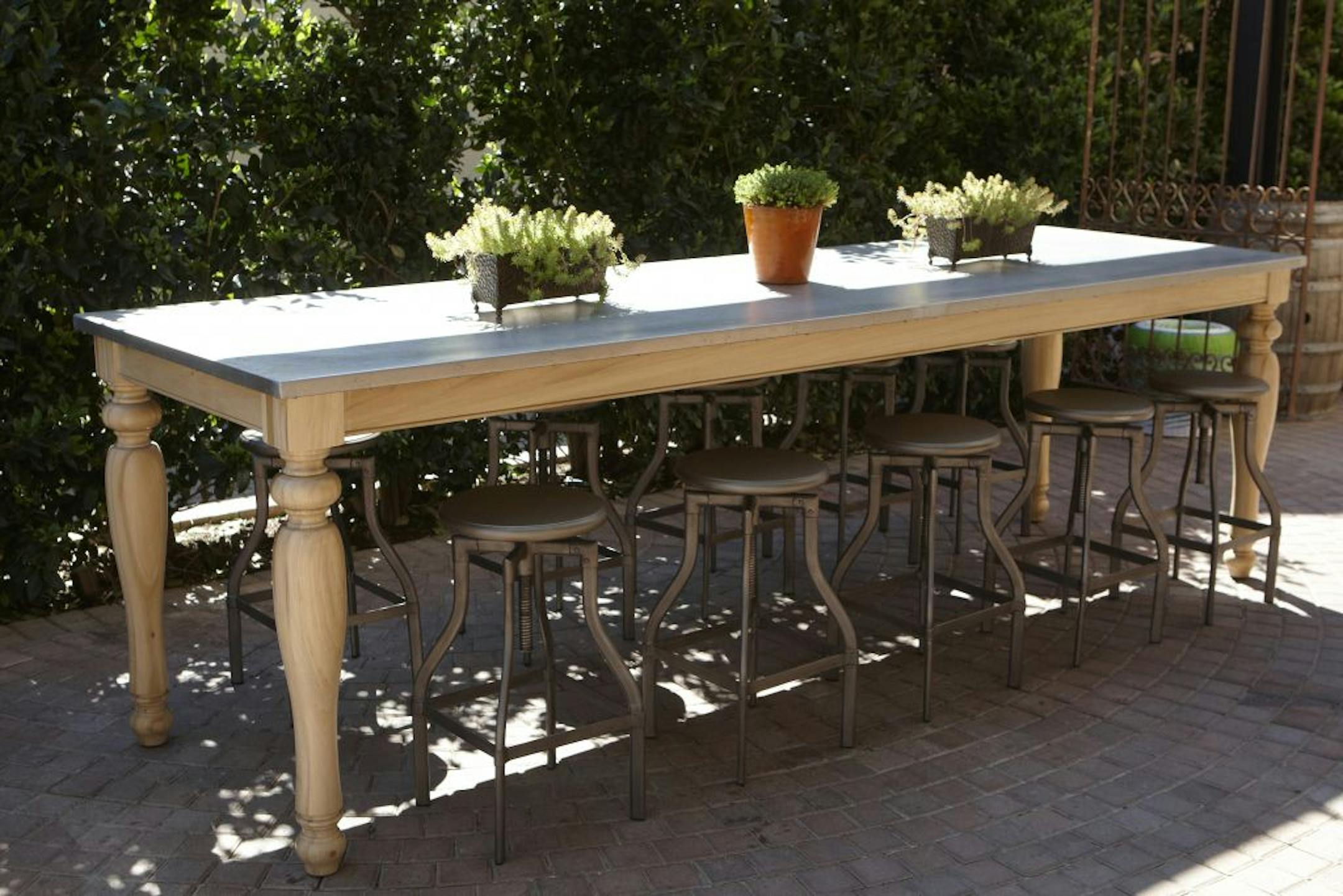 Rectangular dining room table with metal top and wood base (from $750).