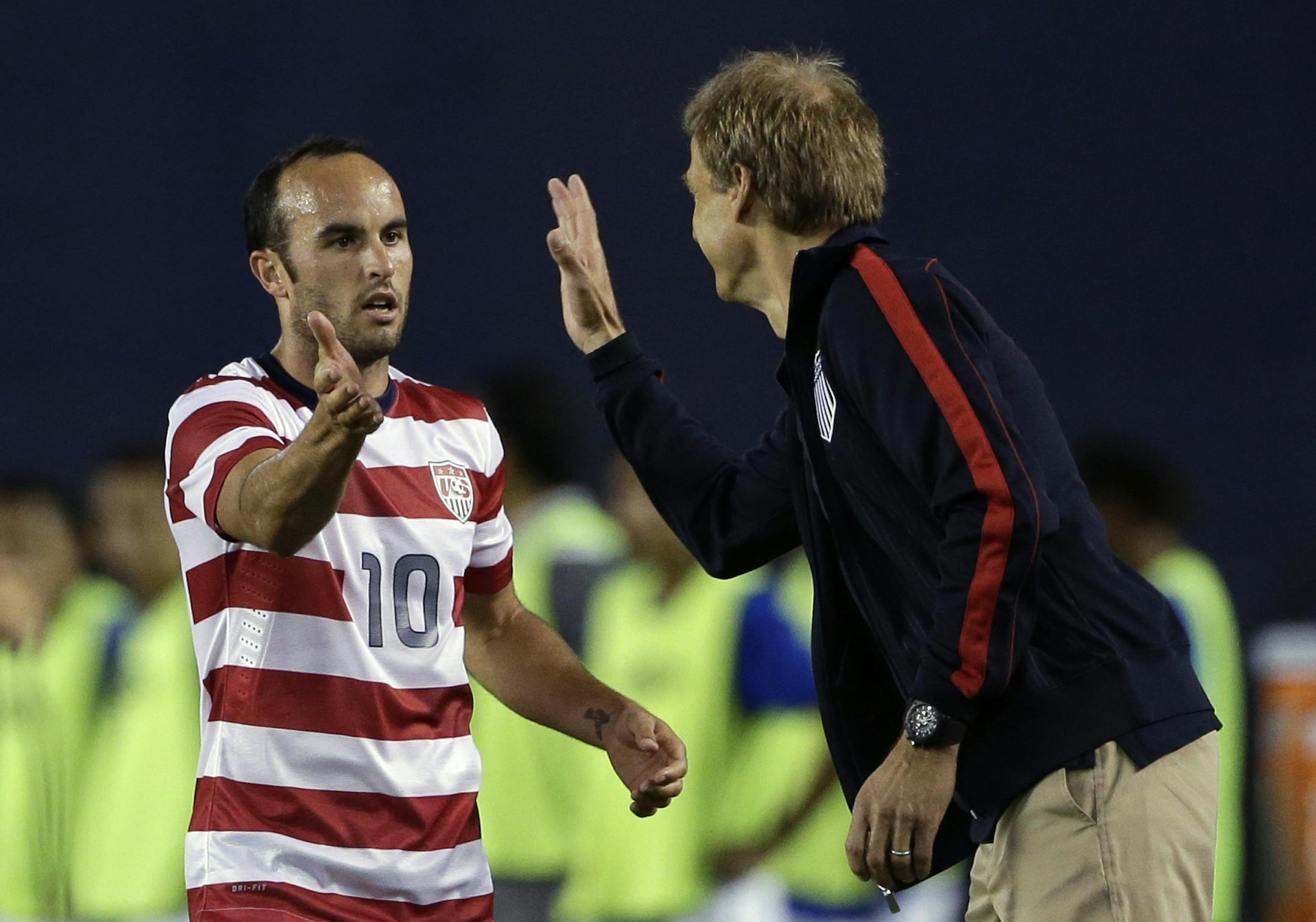 United States coach Jurgen Klinsmann, right, greets Landon Donovan as he comes off the field after scoring his second goal during an international friendly soccer match against Guatemala Friday, July 5, 2013, in San Diego. (AP Photo/Gregory Bull)