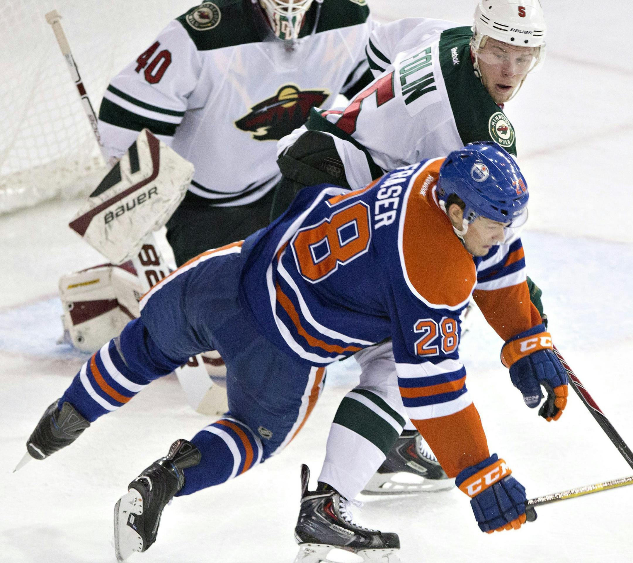 Minnesota Wild's Christian Folin (5) knocks over Edmonton Oilers' Matt Fraser (28) as goalie Devan Dubnyk (40) looks for the puck during the second period of an NHL hockey game Tuesday, Jan. 27, 2015, in Edmonton, Alberta. (AP Photo/The Canadian Press, Jason Franson)