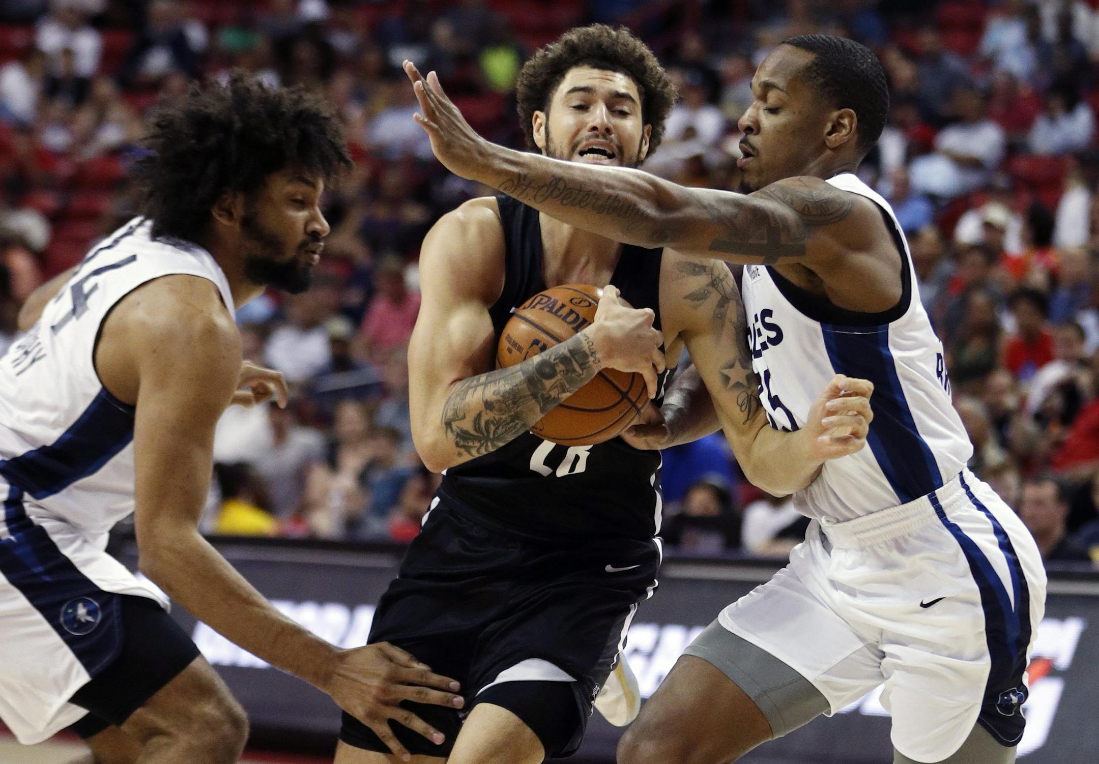 Brooklyn Nets' Isaia Cordinier, center, drives between Minnesota Timberwolves' Jordan Murphy, left, and Barry Brown Jr. during the first half of an NBA summer league basketball game Sunday, July 14, 2019, in Las Vegas. (AP Photo/John Locher)