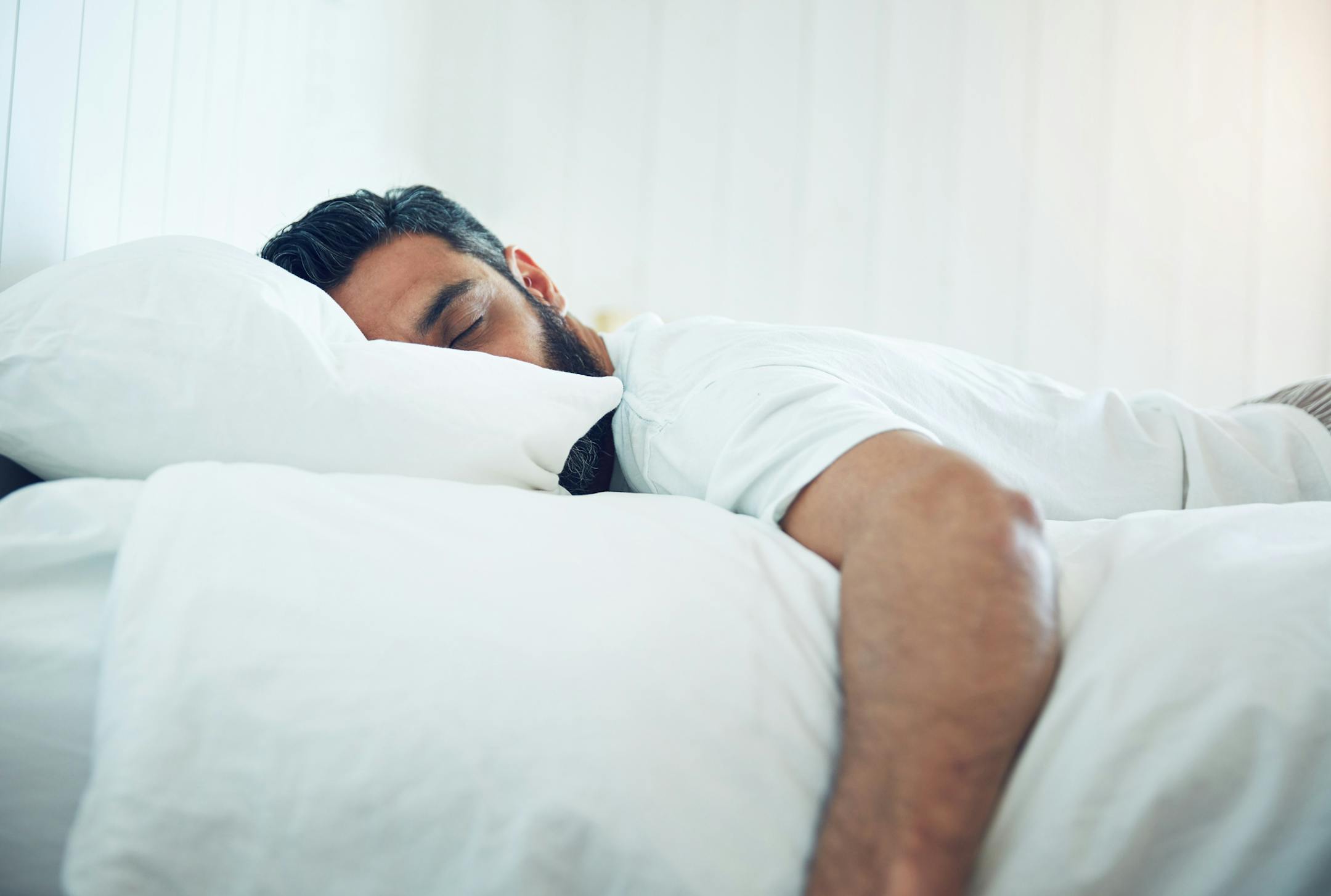 Shot of a mature man lying on his bed and sleeping