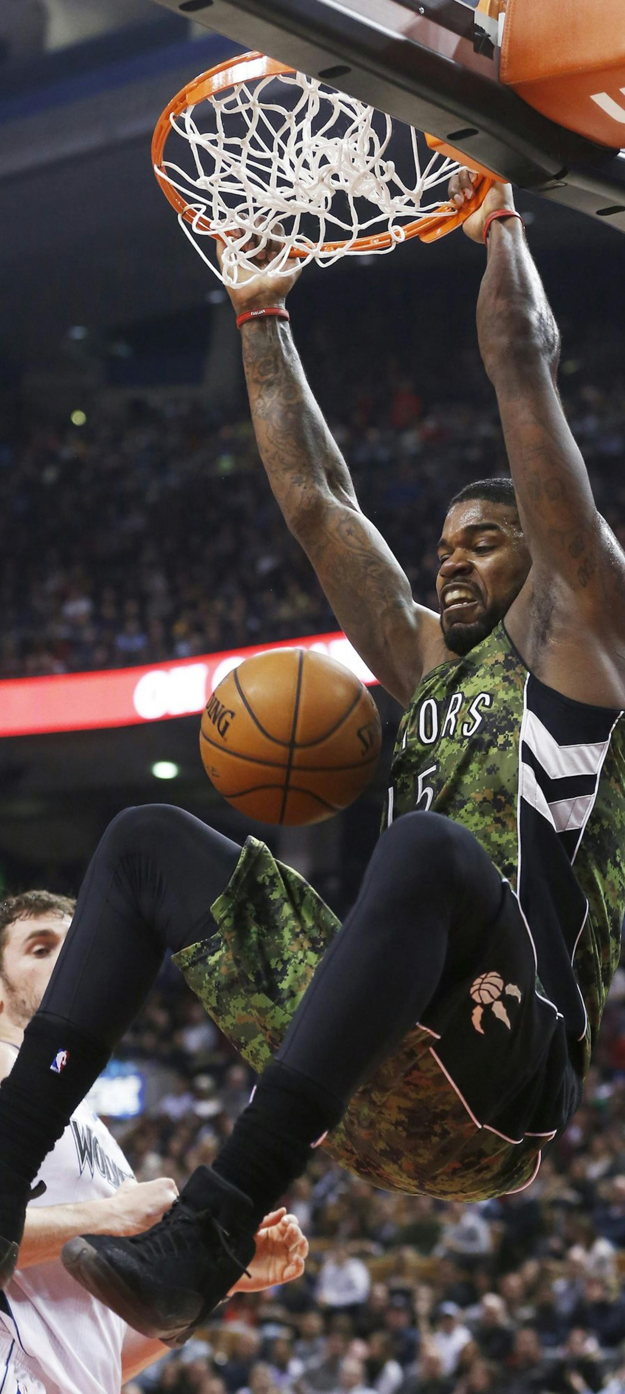Toronto Raptors' Amir Johnson goes up for a dunk in front of Minnesota Timberwolves' Kevin Love, during the first half of an NBA basketball game Friday, Jan. 17, 2014, in Toronto. (AP Photo/The Canadian Press, Mark Blinch)