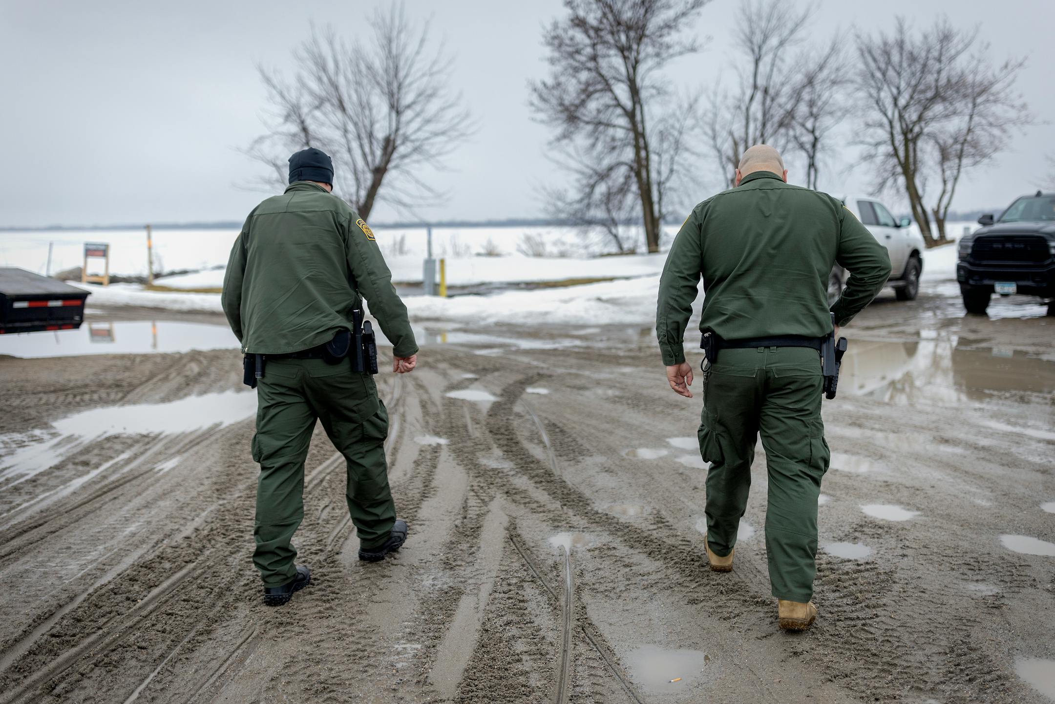 Border Patrol Agents Jared Berg, left, and Mike Johnson, make their way onto Lake of the Woods in Warroad, Minn., on Tuesday, March 22, 2022.