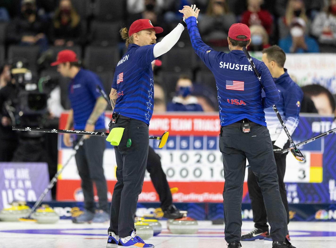 Team Shuster's Matt Hamilton, left, high-fives John Shuster in celebration of their rock placement while competing against Team Dropkin at the U.S. Olympic curling team trials at Baxter Arena in Omaha, Neb., Saturday, Nov. 20, 2021. Team Shuster won 7-3. (AP Photo/Rebecca S. Gratz)