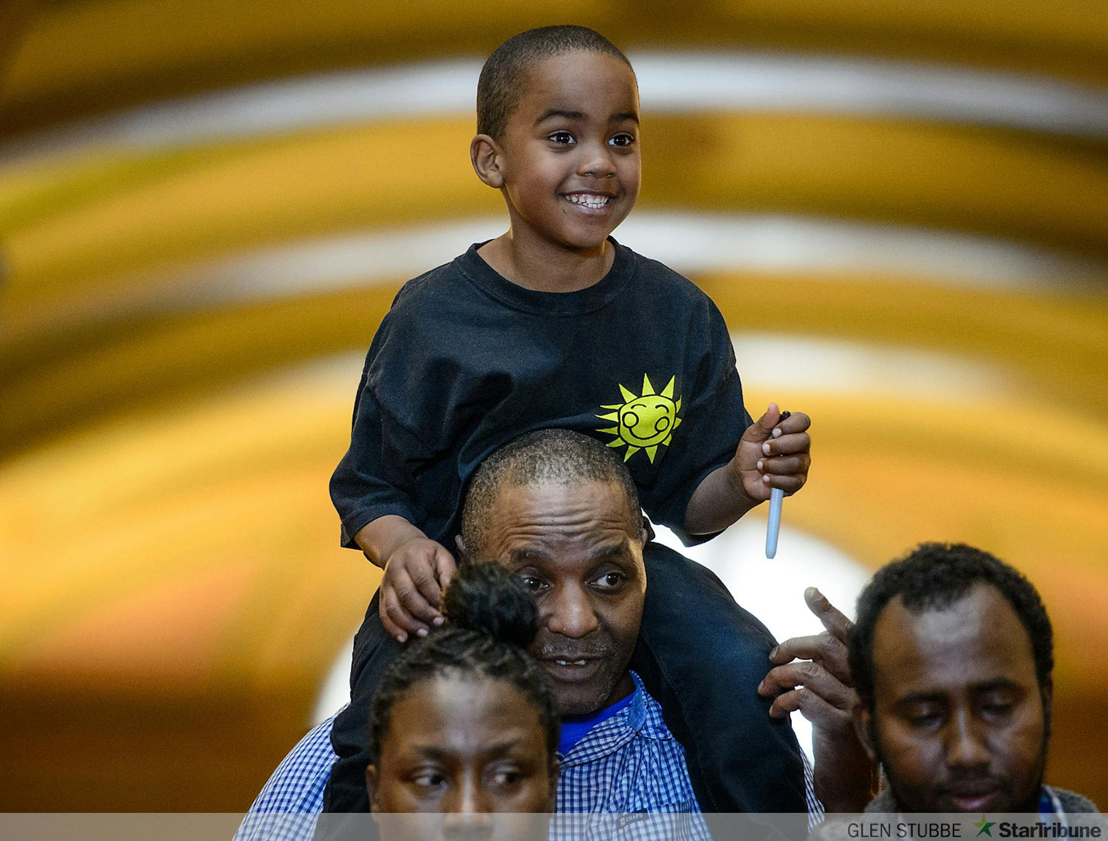 Clutching his bill signing pen, C.J. Flowers sat on his grandfather Al Flowers' shoulders during the ceremony.   Governor Mark Dayton signed the minimum wage bill into law at a public bill signing ceremony Monday the Minnesota State Capitol Rotunda.  The bill, which was passed by the Legislature last week, will increase Minnesota's minimum wage to $9.50 per hour, and index it to inflation.       ]   GLEN STUBBE * gstubbe@startribune.com   Monday, April 14, 2014