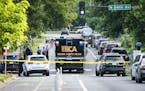 The state Bureau of Criminal Apprehension investigates the scene after Minneapolis police fatally shot a man suspected of shooting and wounding a woma
