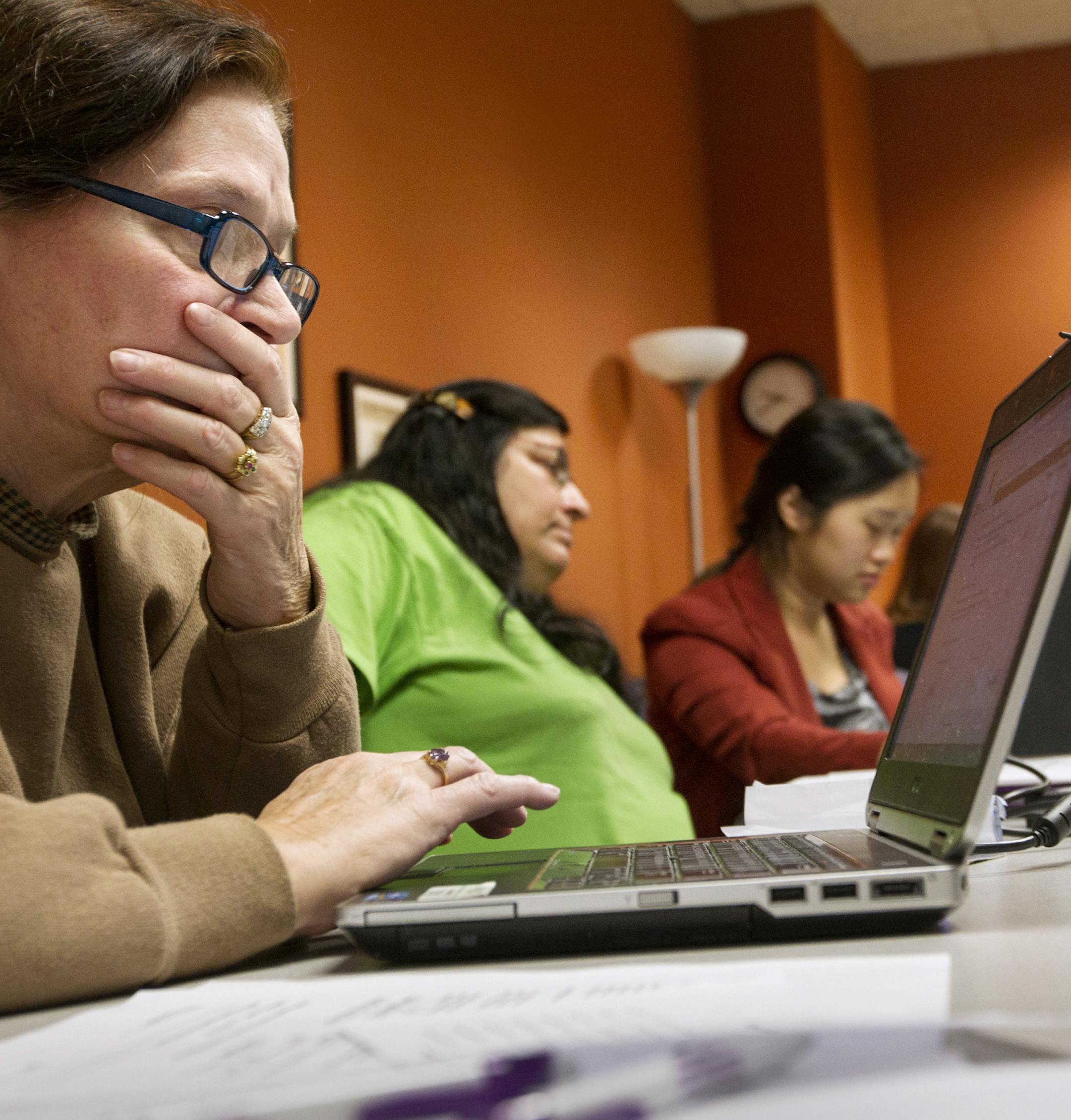 Cherie (first name only given), far left, of St. Paul receives help signing up for MNsure health benefits before the Dec. 23 deadline for Jan. 1 coverage in a small group session at Portico in St. Paul December 21, 2013. (Courtney Perry/Special to the Star Tribune)