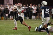 Elk River quarterback Cade Osterman, breaks the tackle of a St. Francis defensive player in the second quarter to score a touchdown in St. Francis .,M