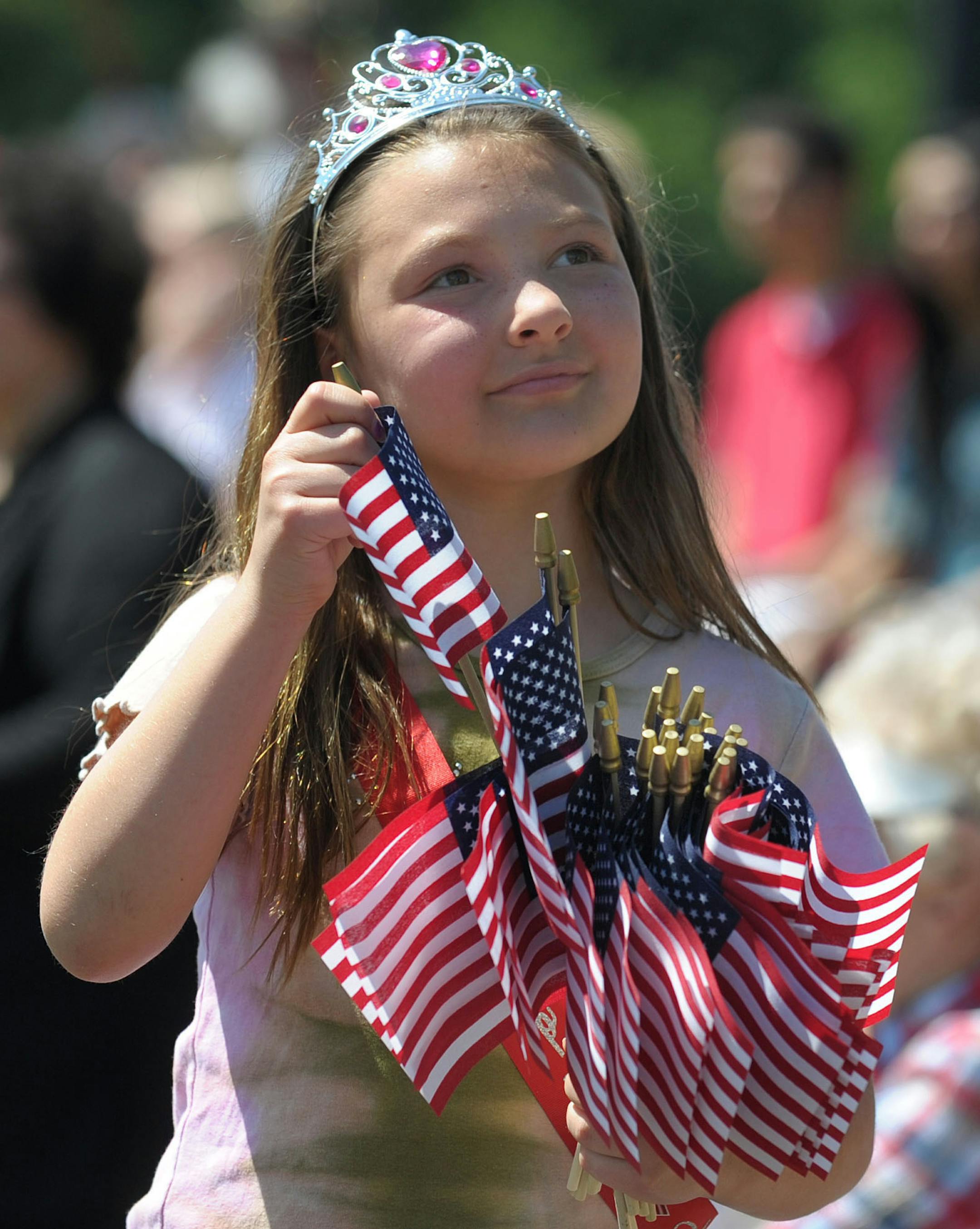 Easton, PA, May 27th, 2013. Bethany Dorsa, 10, of Easton, hands out American flags to attendees during a Memorial Day ceremony following a parade though the downtown Monday morning at Scott Park. (AP Photo/The Express-Times, Matt Smith) ORG XMIT: MIN2013062609284239