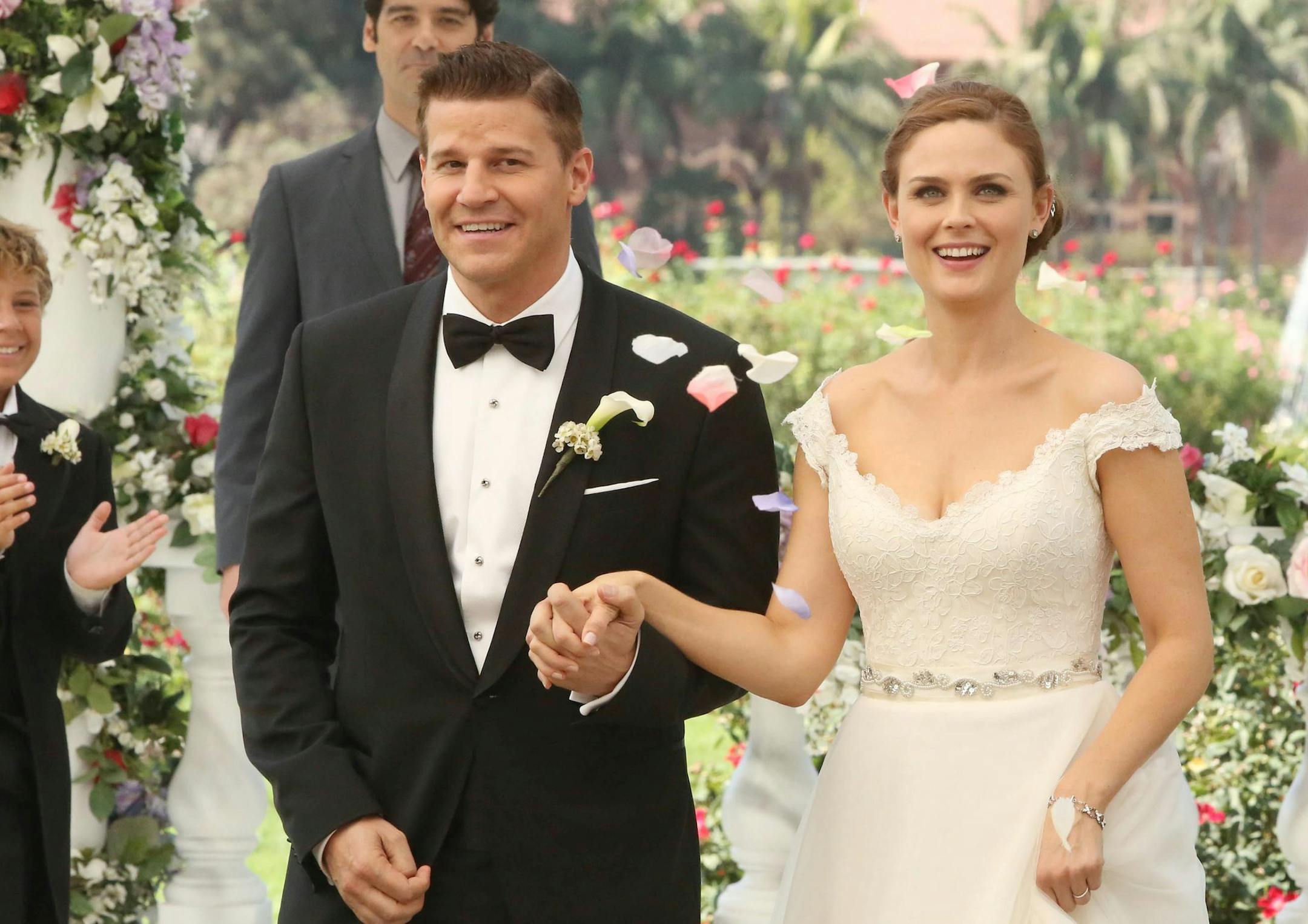 BONES: Brennan (Emily Deschanel, R) and Booth (David Boreanaz, L) at their wedding in the "The Woman in White" episode of BONES airing Monday, Oct. 21 (8:00-9:00 PM ET/PT) on FOX. Also pictured background L-R: guest star Ty Panitz, guest star Mather Zickel and Michaela Conlin. ©2013 Fox Broadcasting Co. Cr: Patrick McElhenney/FOX