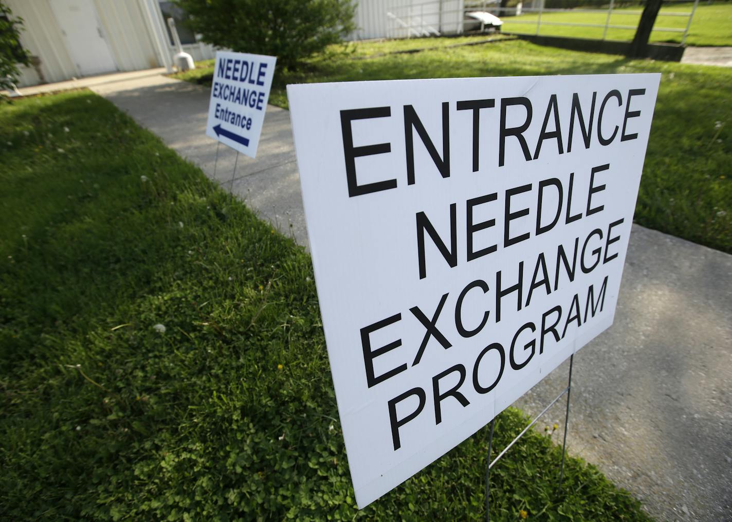 Signs are displayed for the needle exchange program at the Austin Community Outreach Center, Tuesday, April 21, 2015, in Austin, Ind. Participants in the program receive enough needles for one week as a way to deal with needle-sharing. Indiana health officials trying to contain an HIV outbreak tied to needle-sharing among drug users are getting helping from specialists from other states in tracking down about 130 additional people who also may be infected.