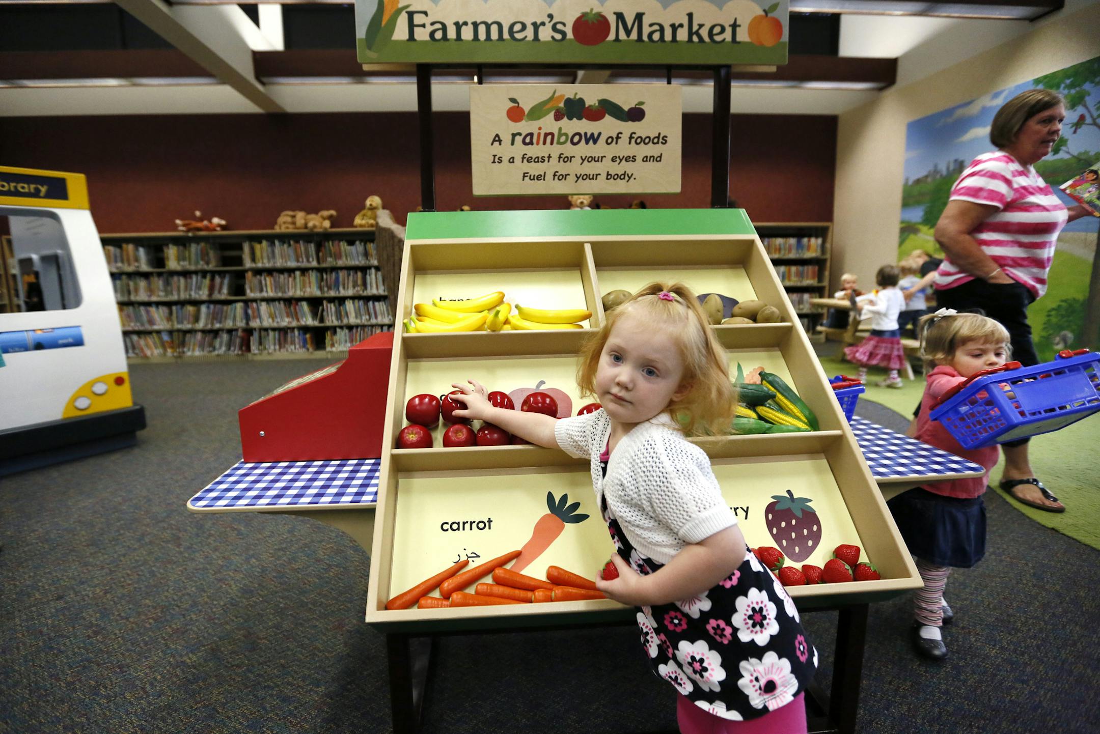 Minnesota's Children Museum is behind a new "Smart Play Spot" at the Anoka County Library in Fridley which includes a play bus and farmer's market. It was funded largely by the State of Minnesota, Clean Water, Land and Legacy Amendment, Arts and Cultural Heritage Fund. This kind of 3D learning experience is part of the evolution of libraries from book depot to hands-on learning lab. Here, 2-year-old Hannah Henderson shops at the farmers market. ] BRIAN PETERSON ‚Ä¢ brianp@startr