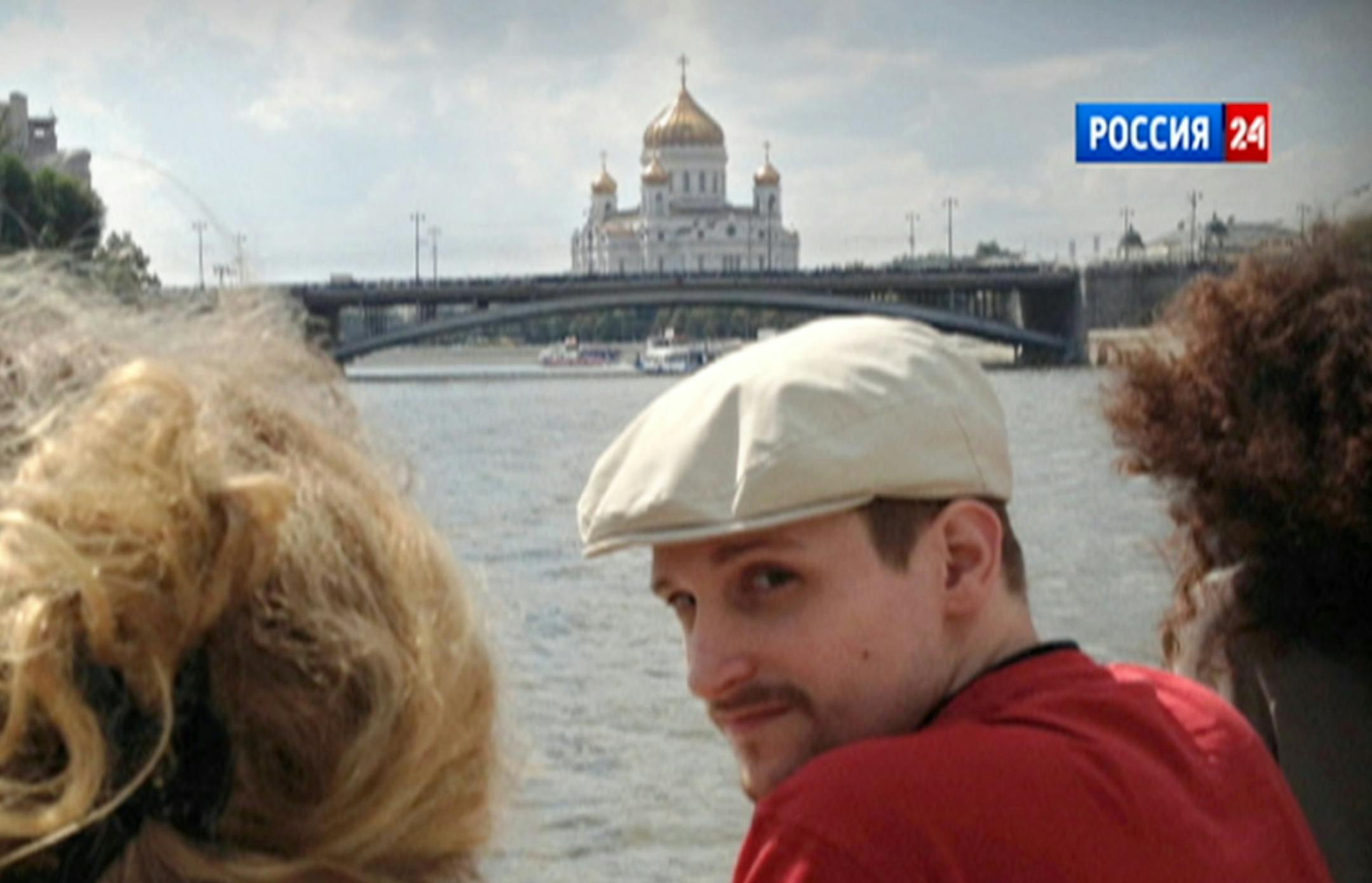 In this video frame grab provided by LifeNews via Rossia 24 TV channel, which has been authenticated based on its contents and other AP reporting, former National Security Agency systems analyst Edward Snowden looks over his shoulder during a boat trip on the Moscow River in Moscow, with the Christ the Savior Cathedral in the background. LifeNews said the video was shot in September 2013 and Snowdenís lawyer, Anatoly Kucherena, confirmed the photo's authenticity. Snowden is calling for inte