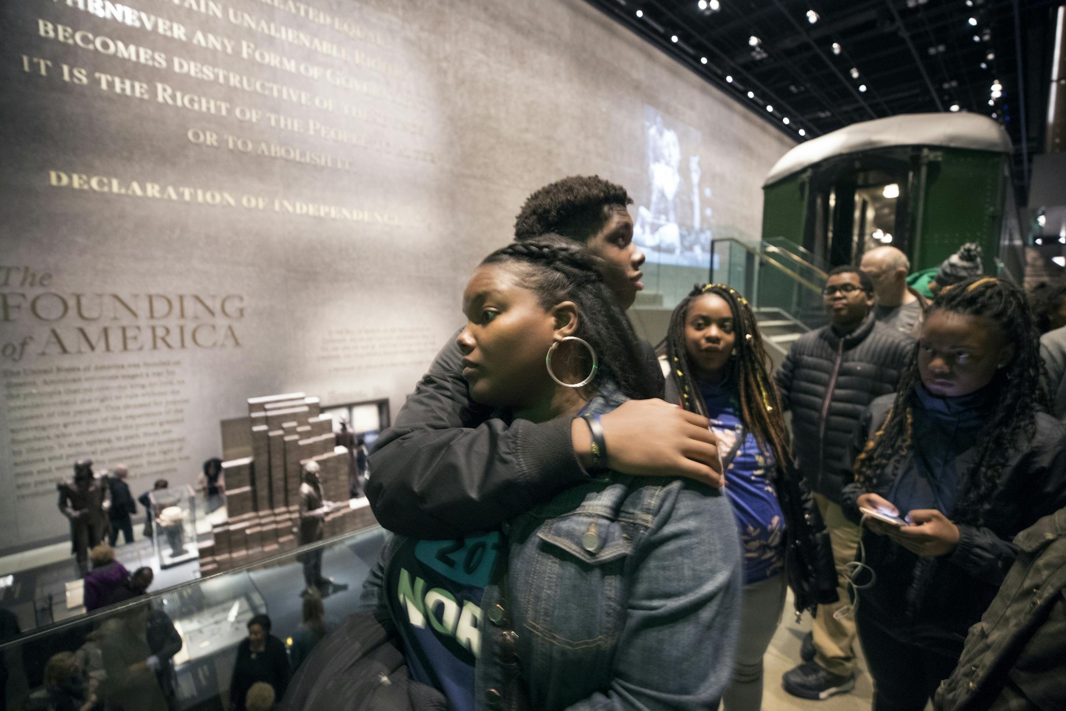 Amil Clark, 15, hugged his mom LaKisha Clark-Burgess while they waited in line to see the Emmett Till exhibit at the National Museum of African American History and Culture The students toured Howard University and the new Smithsonian Museum to learn about African-American history, culture and the civil rights movement Friday, March 23, 2018 in Washington, D.C.