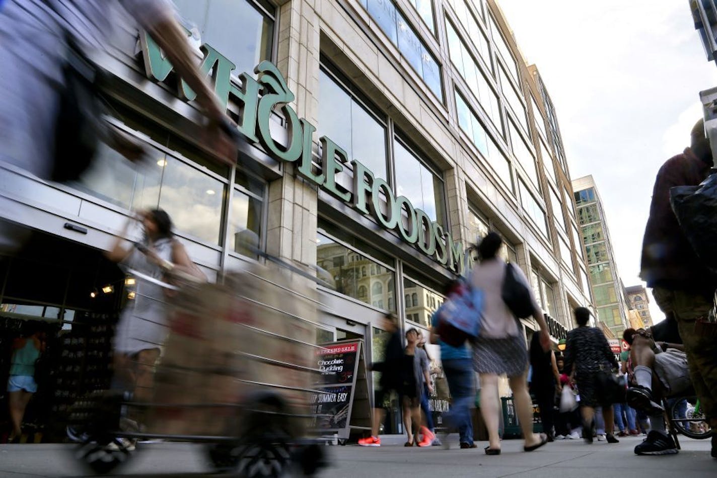 FILE - In this Wednesday, June 24, 2015, file photo, pedestrians pass in front of a Whole Foods Market store in Union Square in New York.