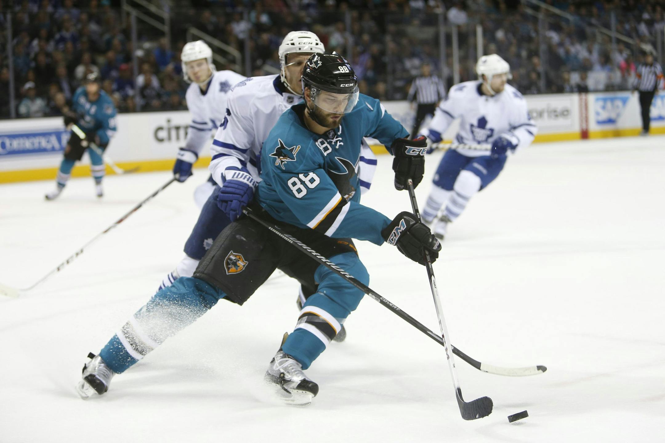 The San Jose Sharks' Brent Burns (88) fights for the puck against the Toronto Maple Leafs' Carl Gunnarsson in the first period at SAP Center in San Jose, Calif., on Tuesday, March 11, 2014. (Josie Lepe/Bay Area News Group/MCT) ORG XMIT: 1150273