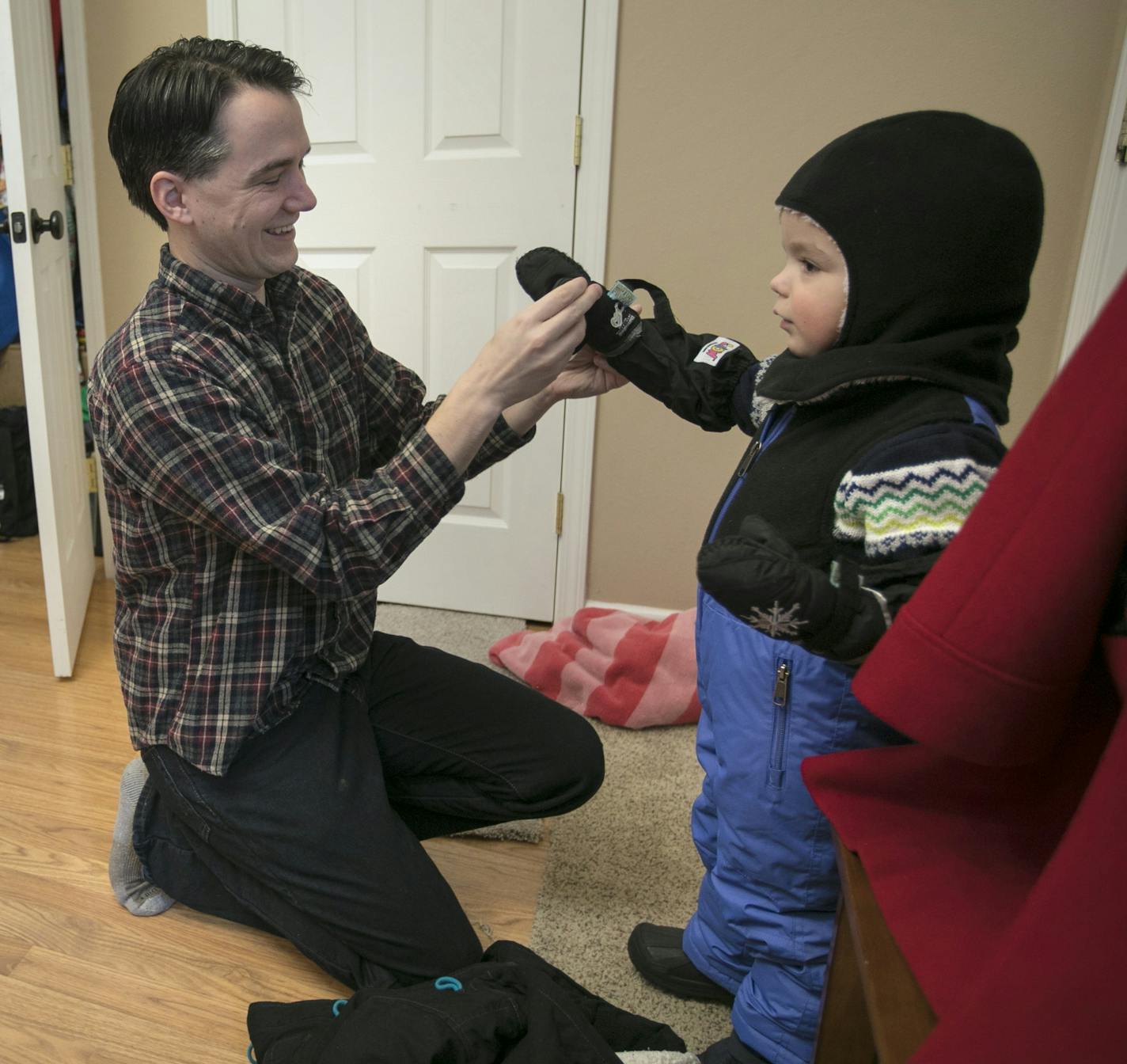 Chris and Briana dress their boys, Charlie (left) and Jack (right), in winter gear before heading out for their first snowmobile ride.