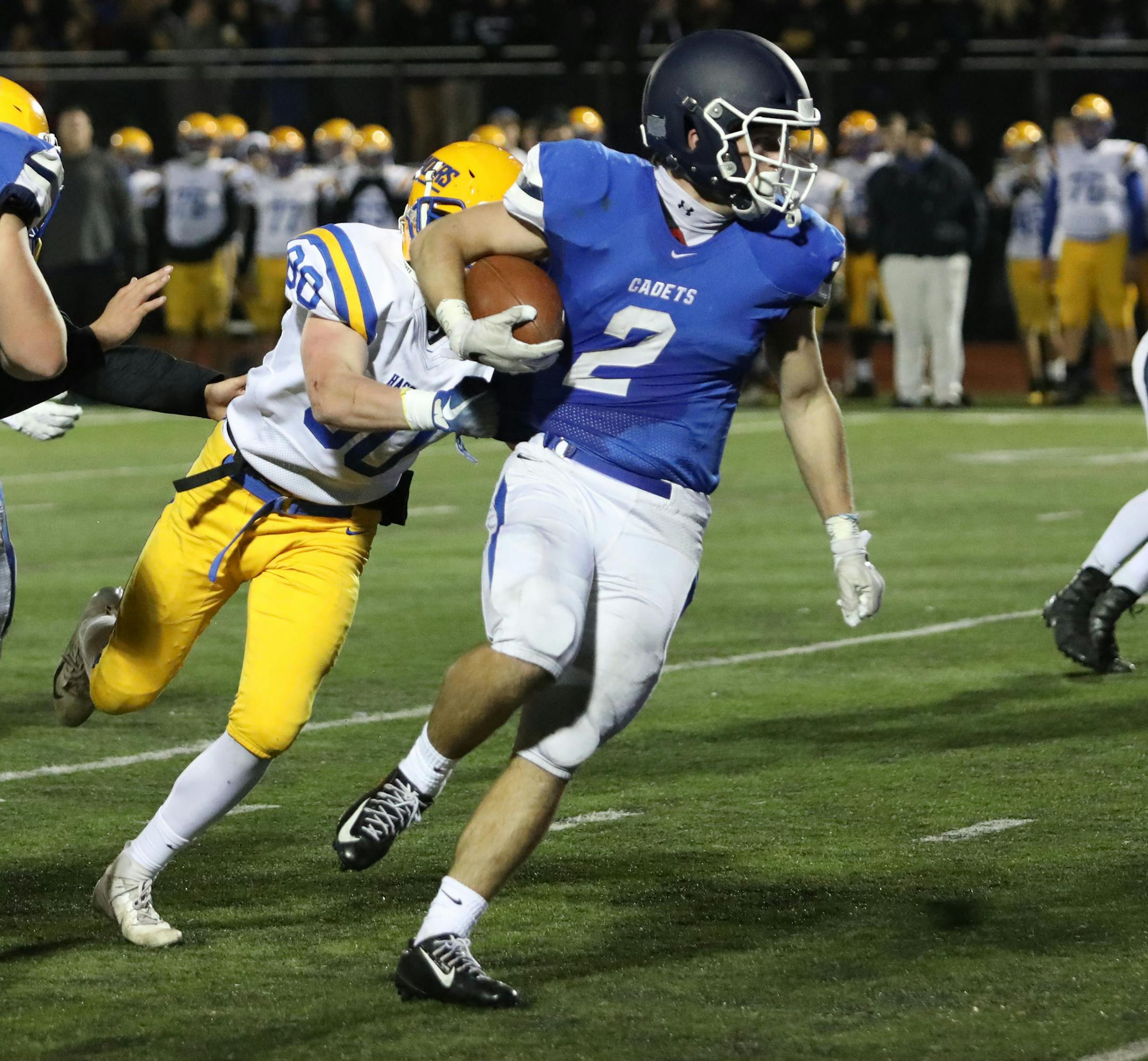 Raider defender Danny Brown (80) hangs onto Brendan McFadden (2) by the shirttail. McFadden led St. Thomas Academy to a 41-6 win over Hastings with 159 rushing yards and four first half touchdowns. Photo by Cheryl Myers, SportsEngine