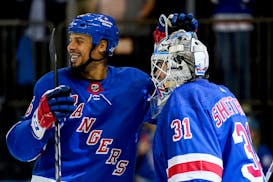 New York Rangers right wing Ryan Reaves, left, congratulated goaltender Igor Shesterkin, who made 25 saves in Tuesday night's season-opening victory.