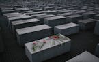 In this Tuesday, Jan. 27, 2015 file photo, flowers lay on a concrete slab of the Holocaust Memorial to mark the International Holocaust Remembrance Da
