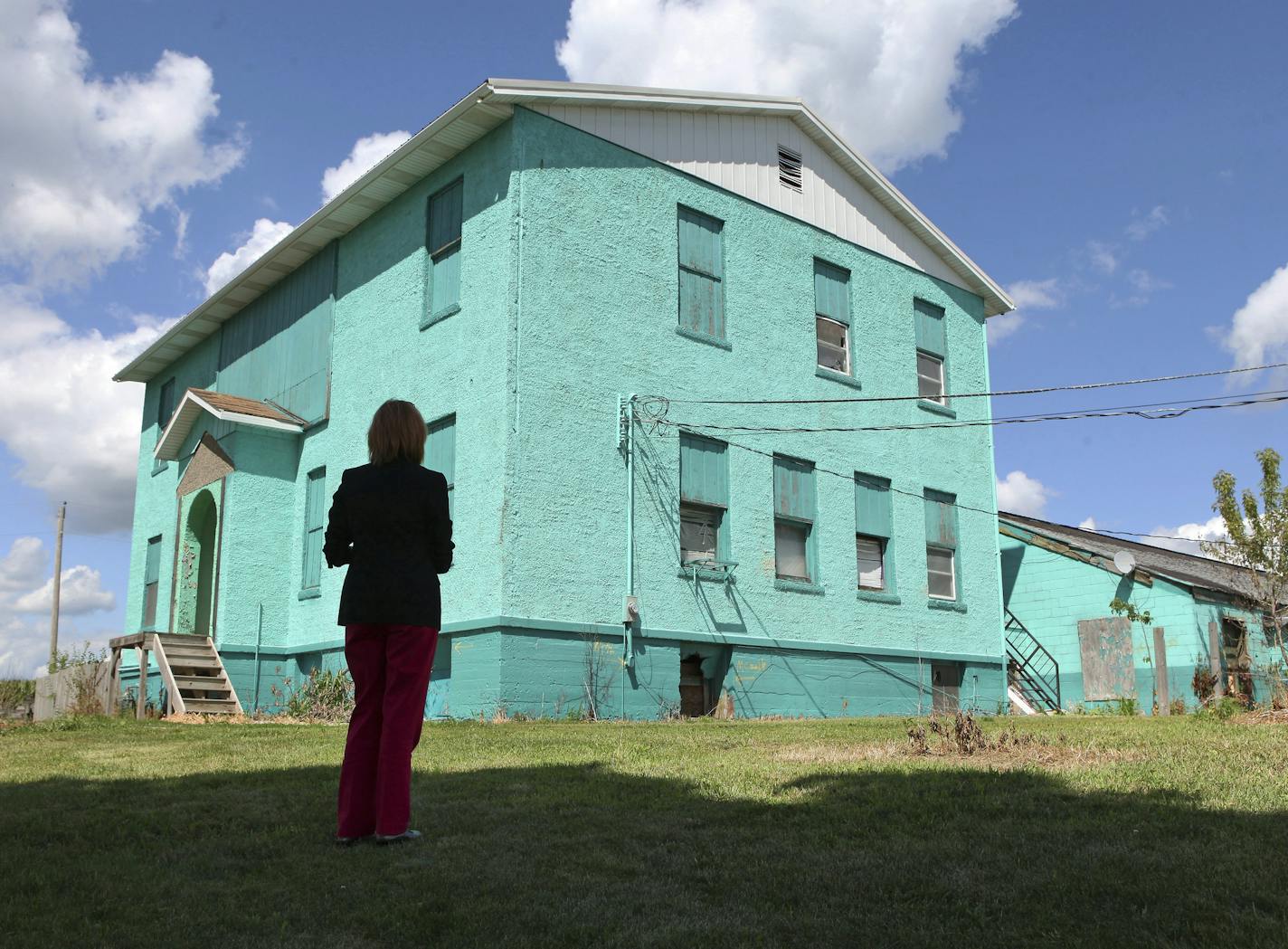 FILE -- A social worker revisits the old schoolhouse that was used as a bunkhouse for the men who worked at Henry's Turkey Service in Atalissa, Iowa, July 20, 2013. More than six years after their rescue from virtual servitude, in which they worked for little pay in a turkey-processing plant while living in the decrepit Iowa schoolhouse, more than two dozen men with intellectual disability will share nearly $600,000 owed to them, following a federal court order issued Thursday. (Nicole Bengiveno