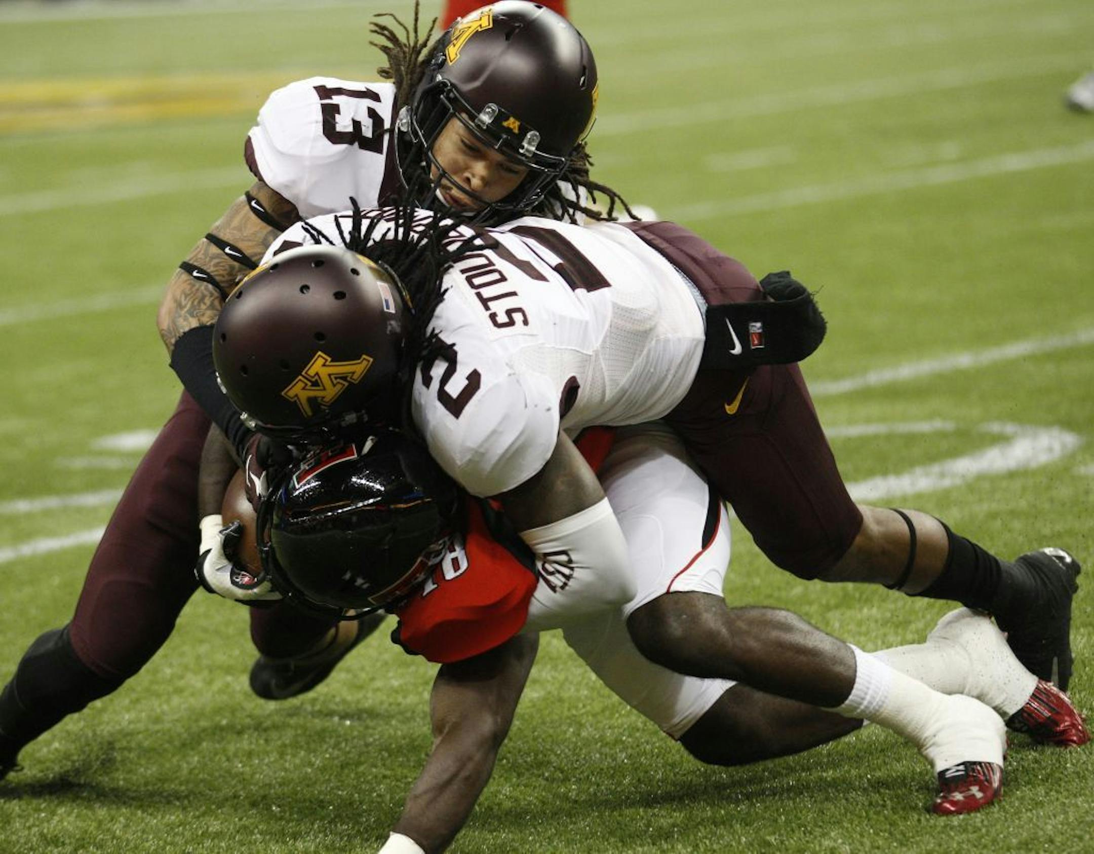 Minnesota's Derrick Wells and Troy Stoudermire wrap up Texas Tech's Eric Ward during the first quarter of the Meineke Car Care Bowl of Texas on Friday, December 28, 2012, at Reliant Stadium in Houston, Texas.