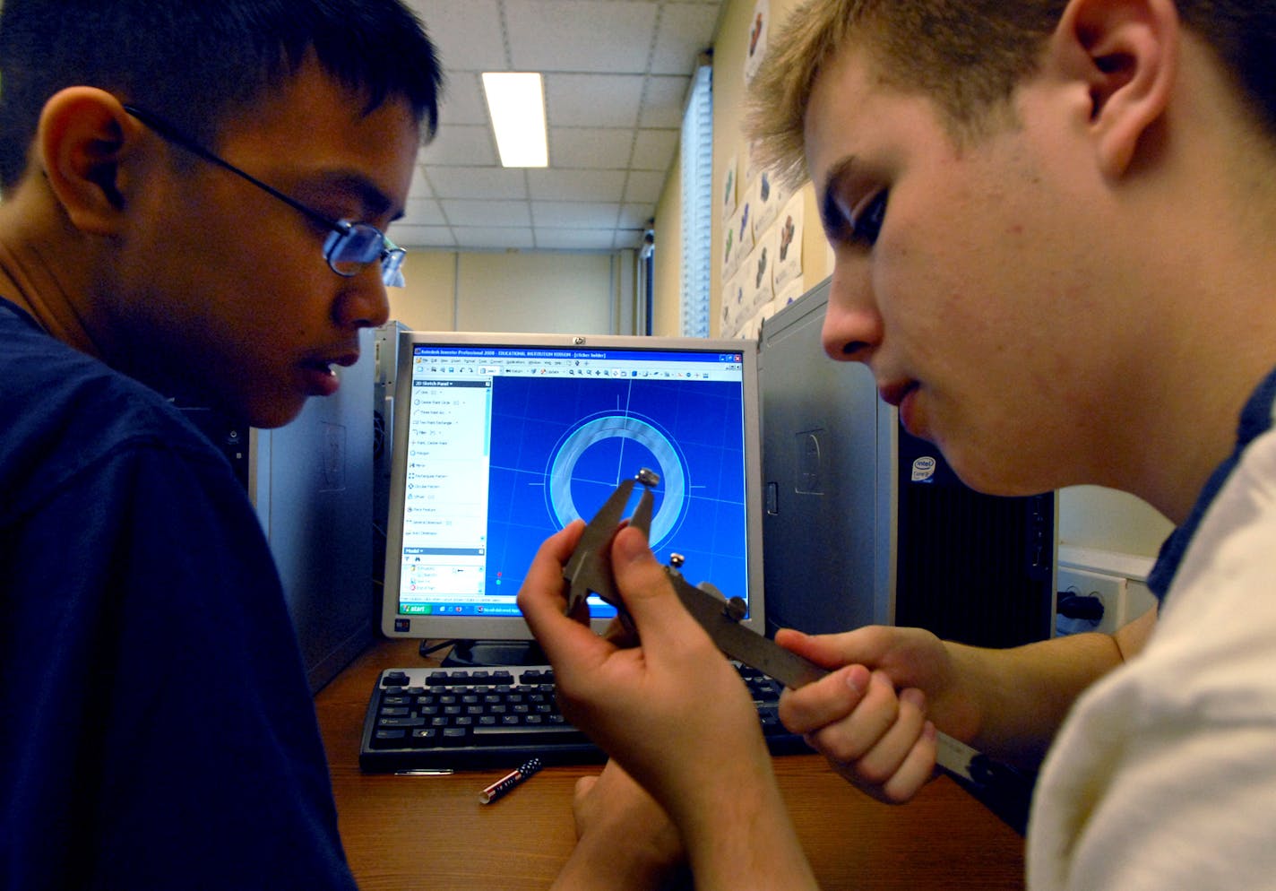 Ninth-graders Dan Dinh and Jacob Pithan worked on a project in their introduction to engineering design class at Blaine High School. Pithan used a dial caliper to measure the "clicker holder" for a pen they are redesigning on the computer.