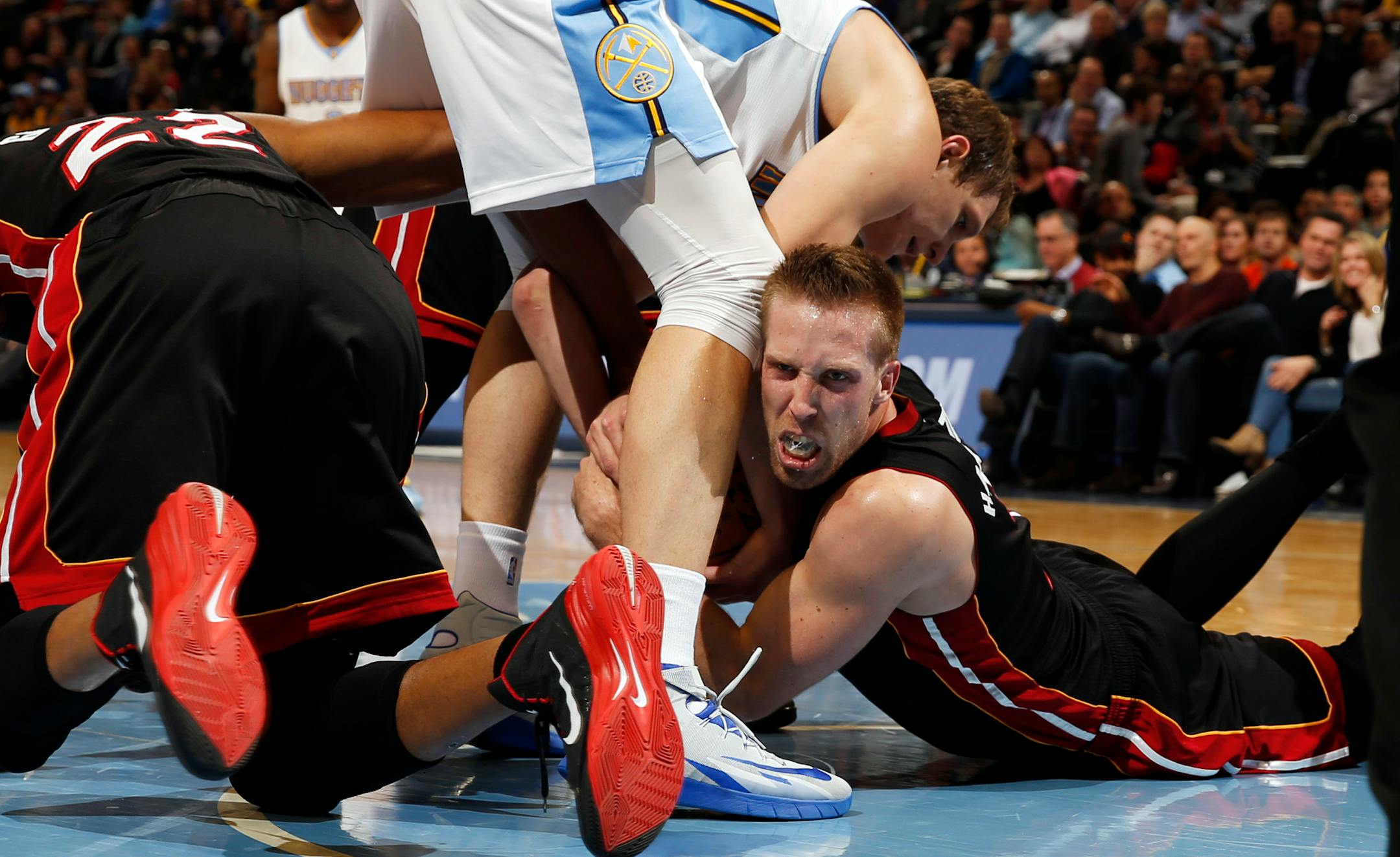 Miami Heat center Justin Hamilton, right, fights for control of a loose ball with Denver Nuggets center Timofey Mozgov, of Russia, as Heat forward Danny Granger, left, tires to help in the third quarter of an NBA basketball game in Denver on Wednesday, Dec. 10, 2014. (AP Photo/David Zalubowski)