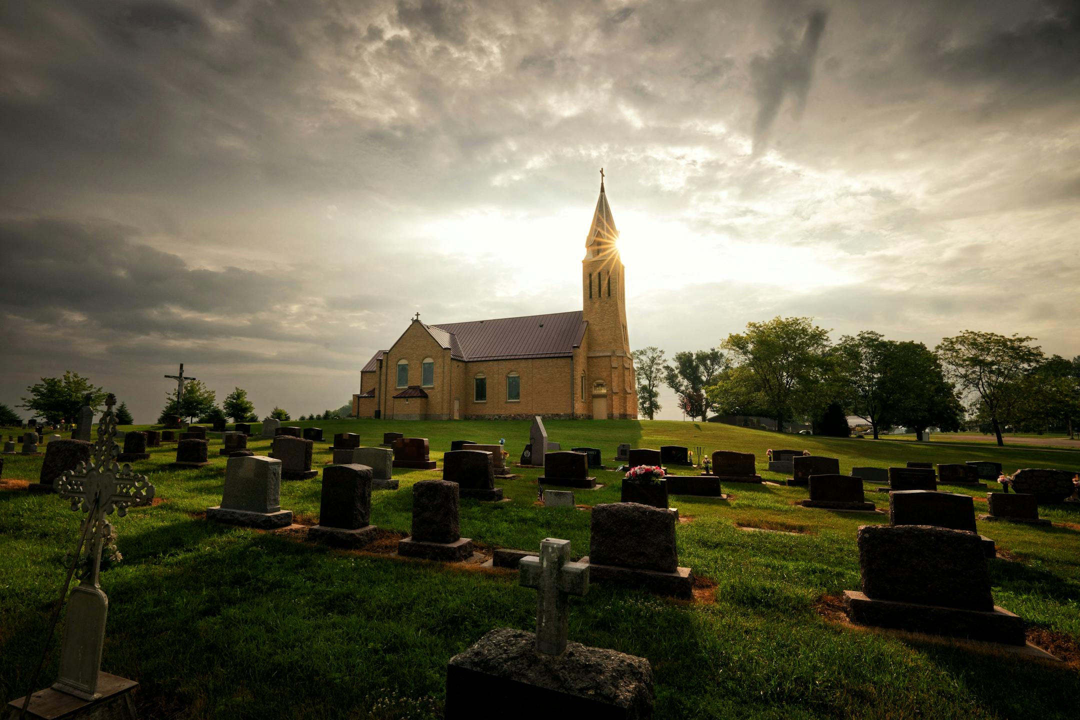 The Sun rises over St. Joseph Church before Friday morning mass  Friday, June 23, 2023  Rosen, Minn.  Parishioners from St. Joseph's Church are fighting to keep their church which is slated to be merged in July and potentially closed or demolished as part of the Diocese of New Ulm's strategic plan to deal with priest shortages and shrinking congregations.