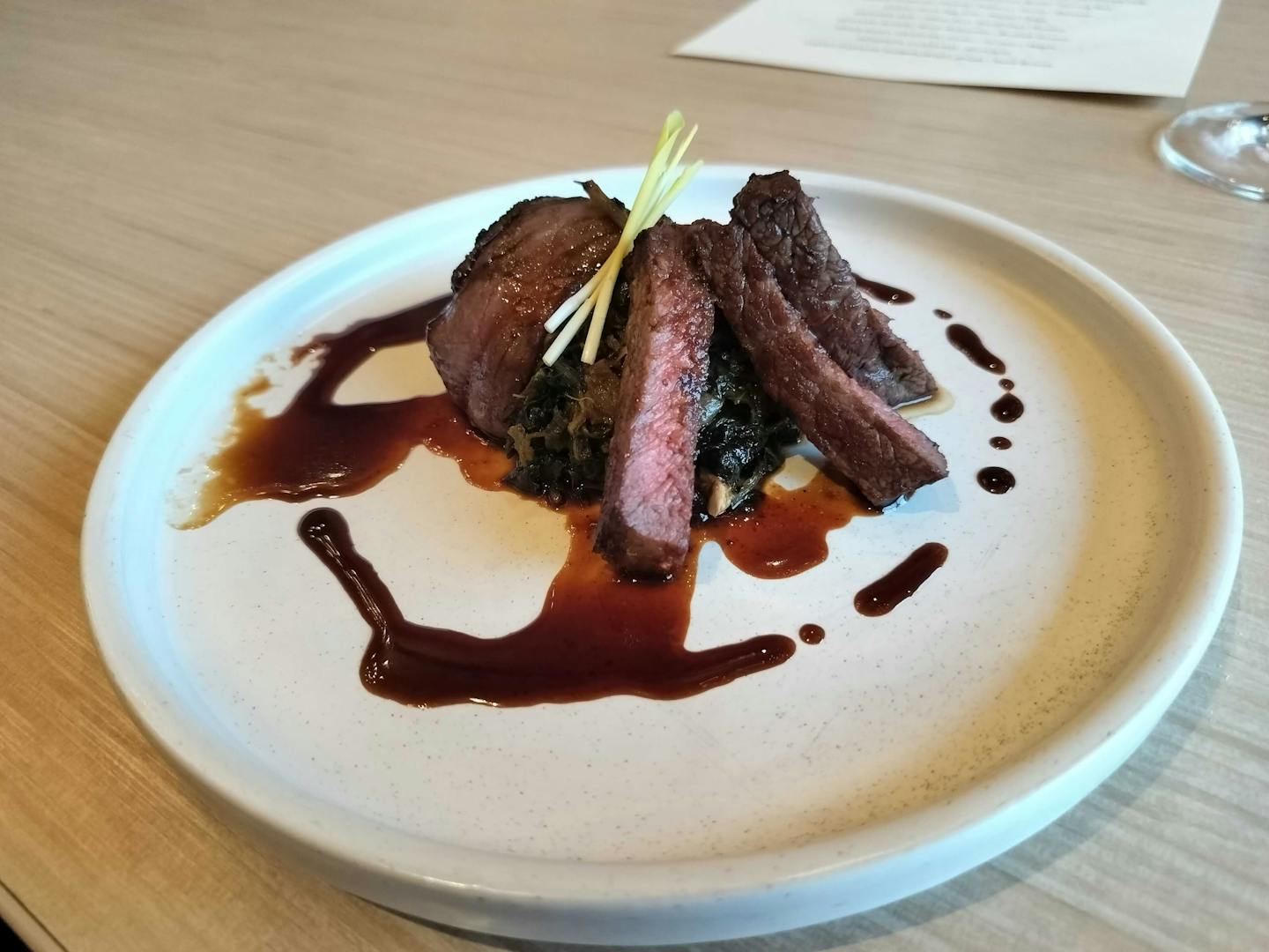 Smoked bison with braised greens is one of the courses in Owamni's new tasting menu.