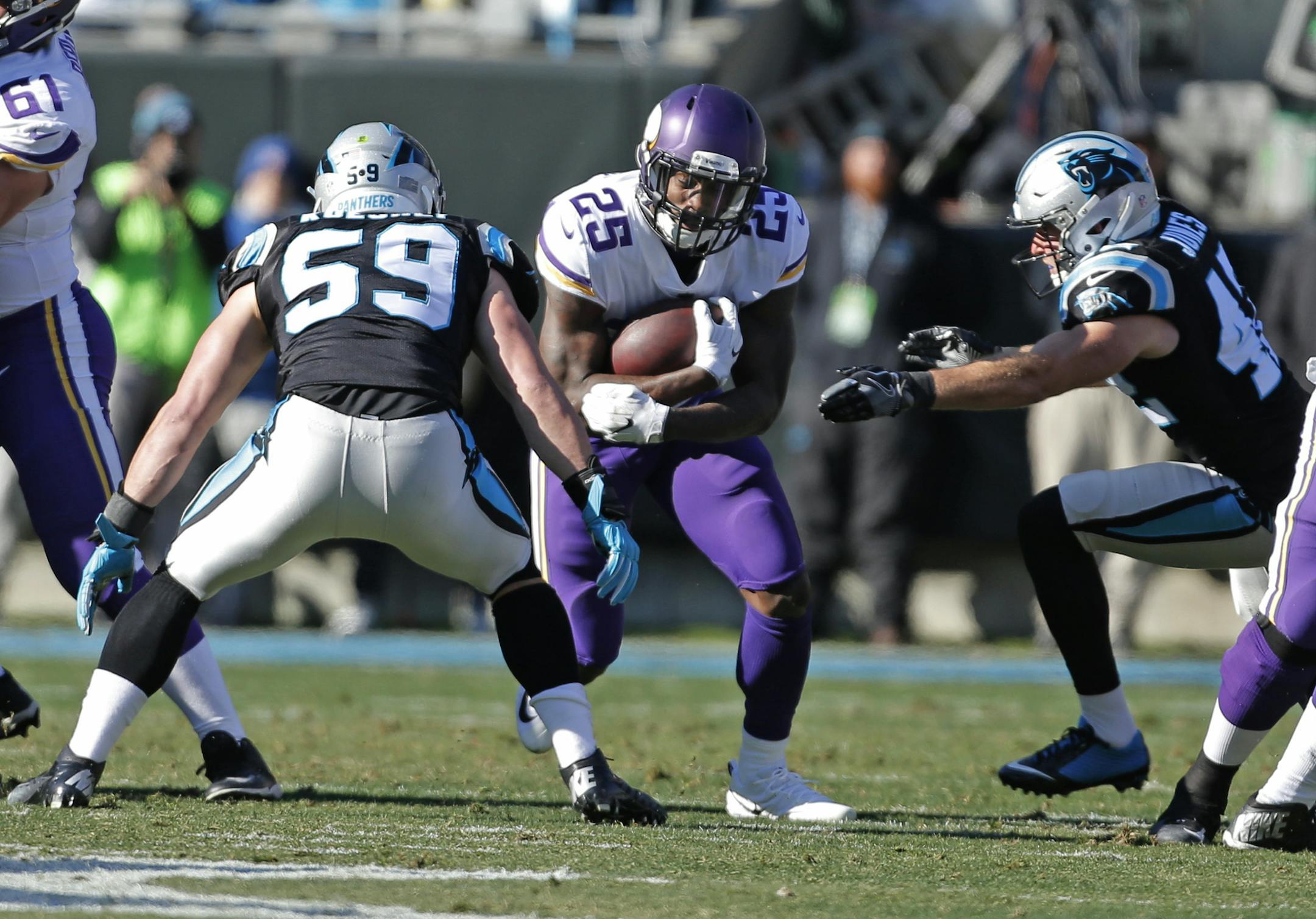 Minnesota Vikings' Latavius Murray (25) runs as Carolina Panthers' Luke Kuechly (59) and Colin Jones (42) defend during the first half of an NFL football game in Charlotte, N.C., Sunday, Dec. 10, 2017. (AP Photo/Bob Leverone)