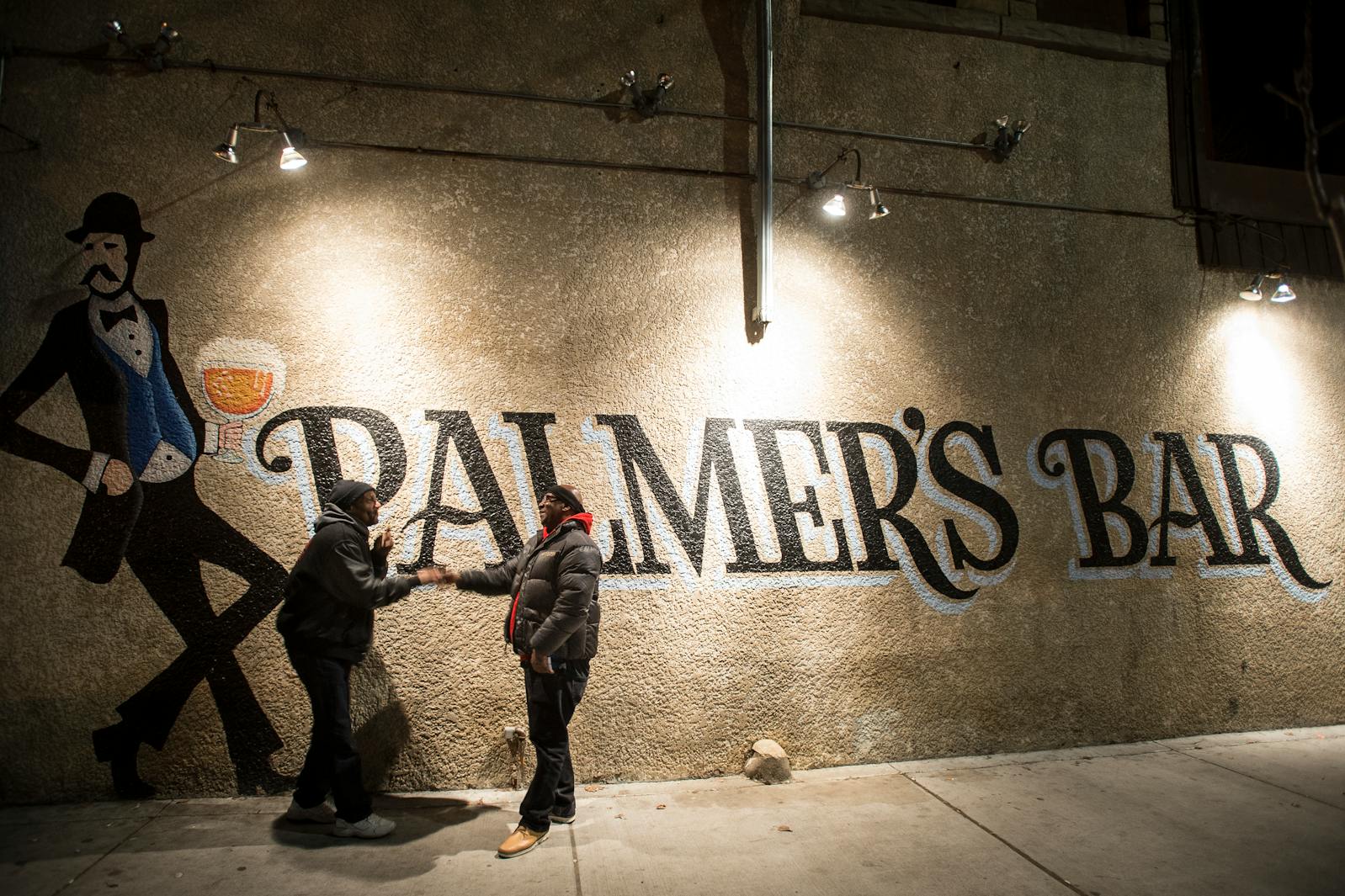 Palmer's Bar patrons, who go by the names "R.D." and "C," shake hands before parting ways outside the legendary Minneapolis dive bar, which will close permanently in September.