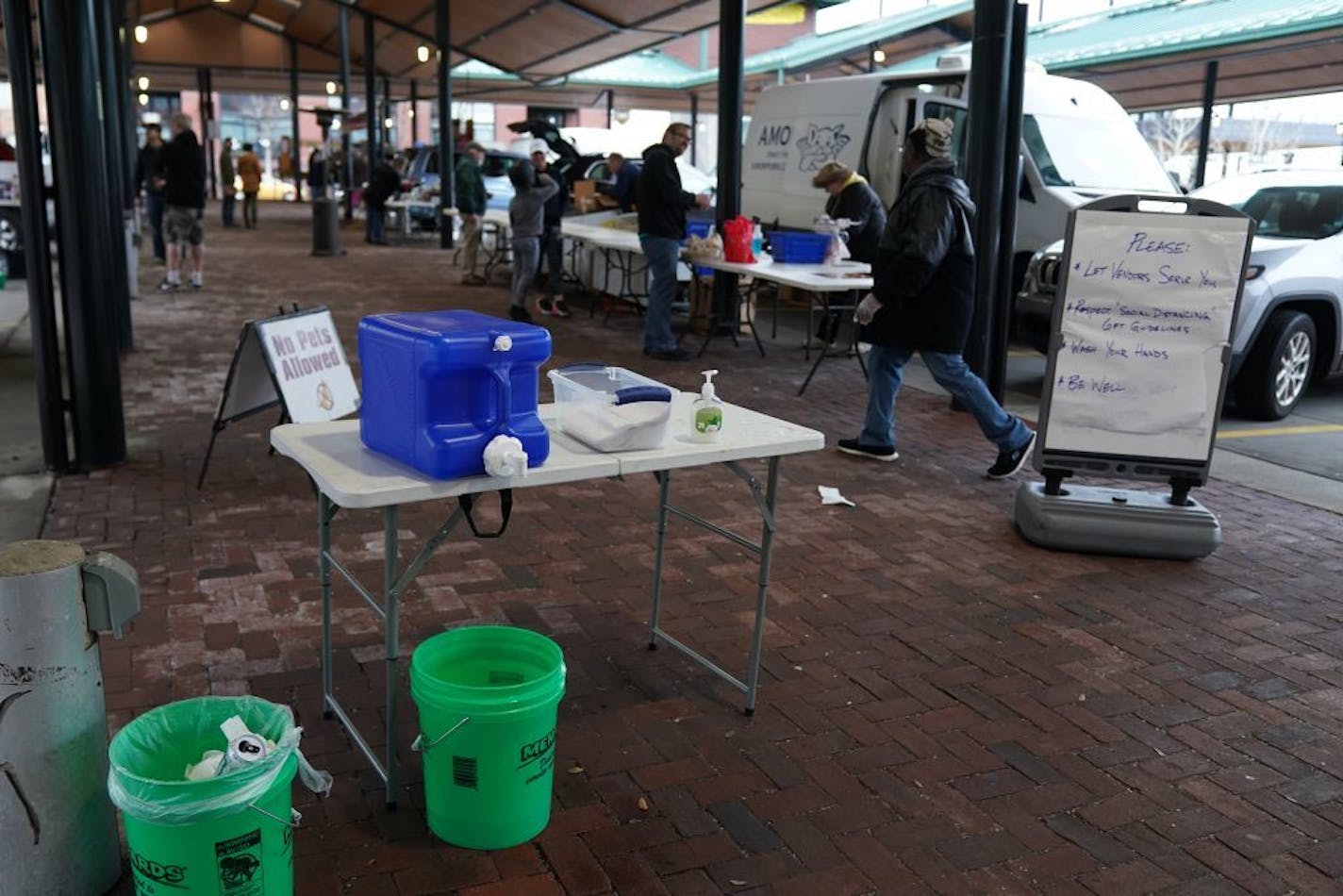 Hand washing stations and signs with reminders to respect social distancing and to let venders serve greeted shoppers at the St. Paul Farmer's Market in Lowertown.