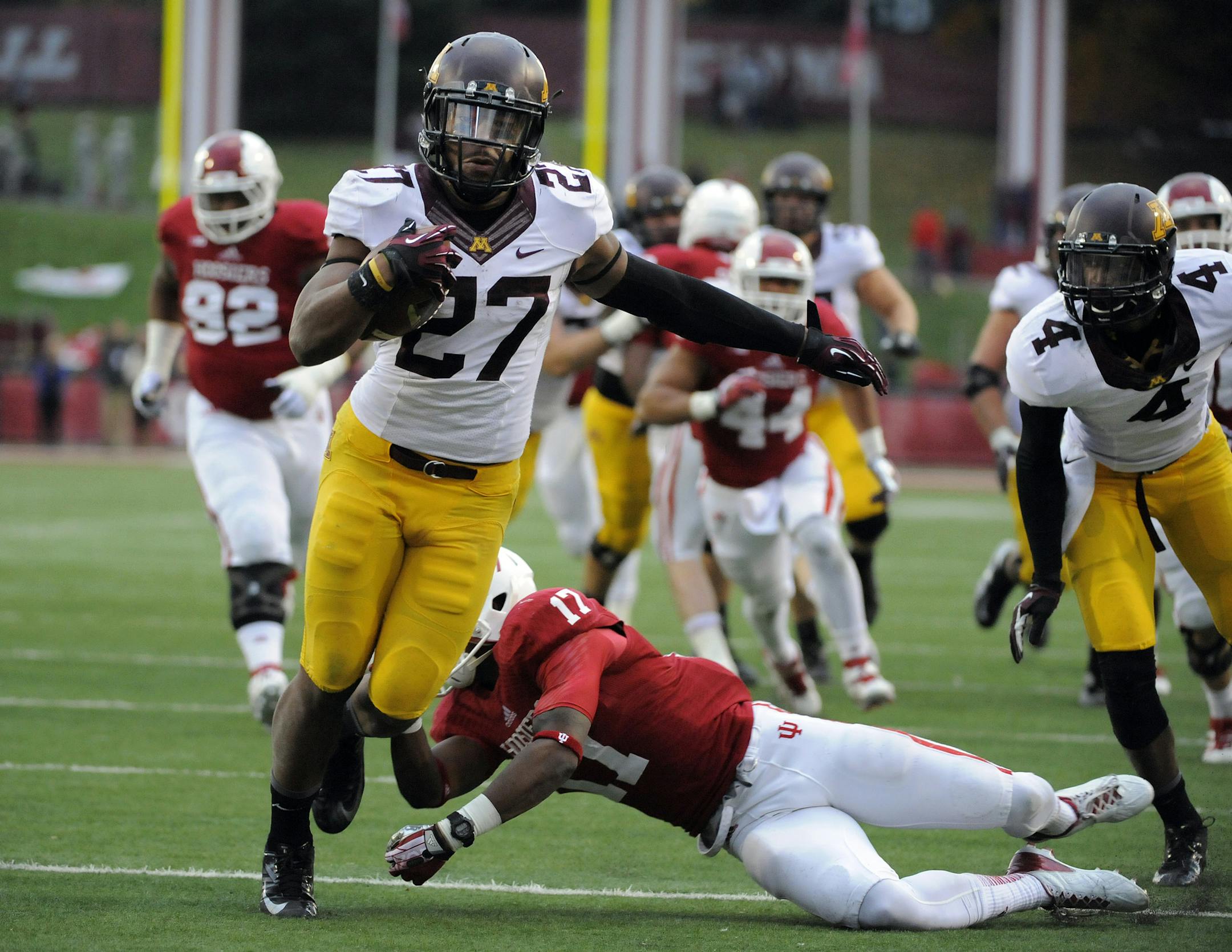 Minnesota's David Cobb (27) runs as Indiana's Michael Hunter (17) defends during the second half of an NCAA college football game in Bloomington, Ind., Saturday, Nov. 2, 2013. Minnesota won 42-39. (AP Photo/ Alan Petersime)