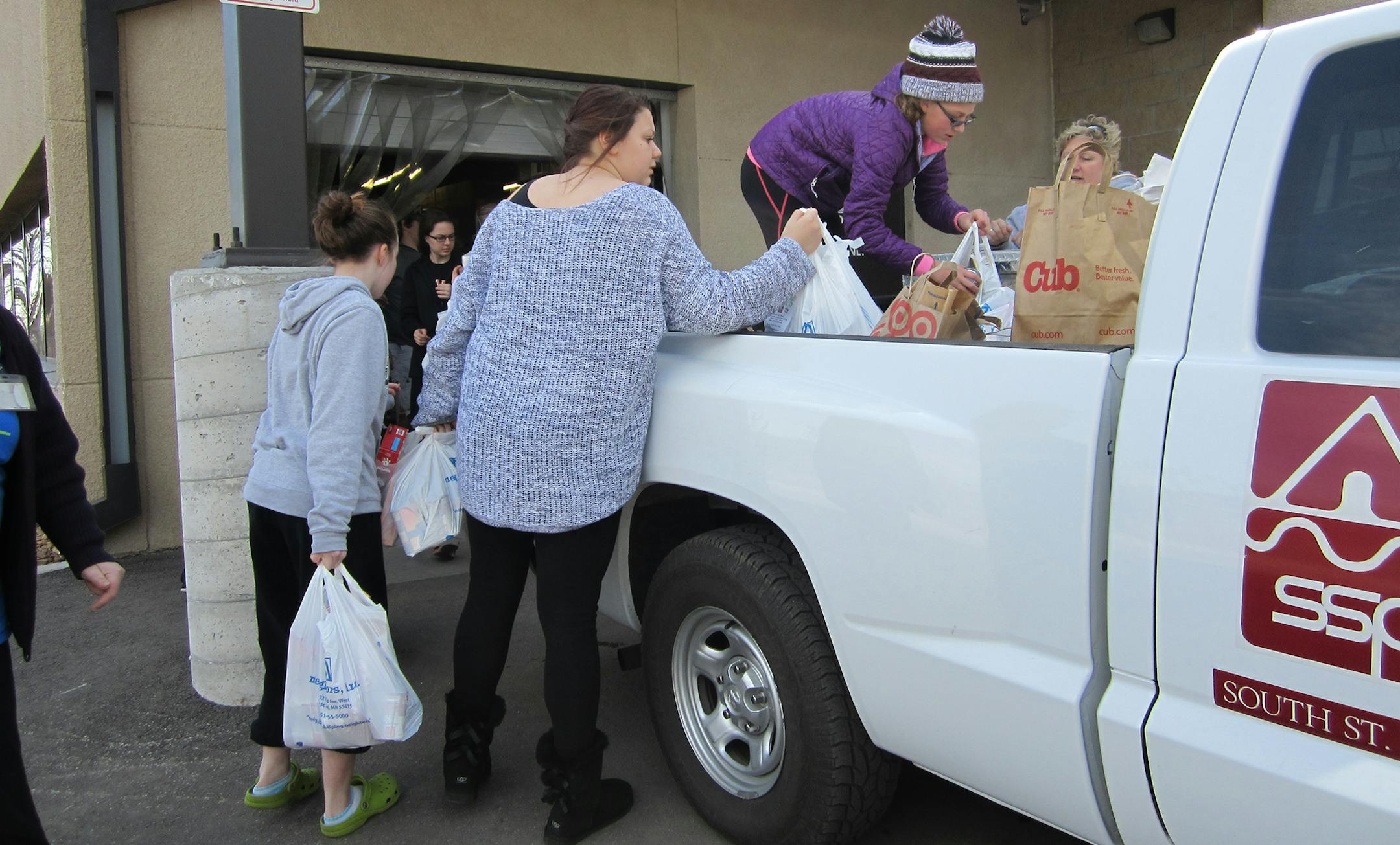 Volunteers load food from a truck into boxes to be weighed at Neighbors Inc. on Saturday, March 21. The group brought in more than 2,000 pounds of food from its four-hour event that day. Photo by Janice Bitters, Special to the Star Tribune