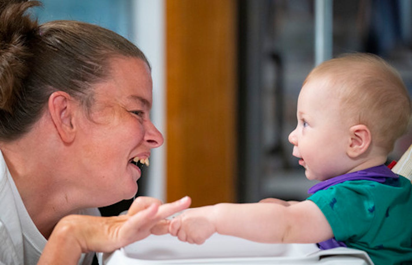 Marrie Bottelson plays with her caregiver and roommate's son, Orin Lundberg, 6 months, Friday, July 29, 2022 in her home in Brooklyn Park, Minn. ]