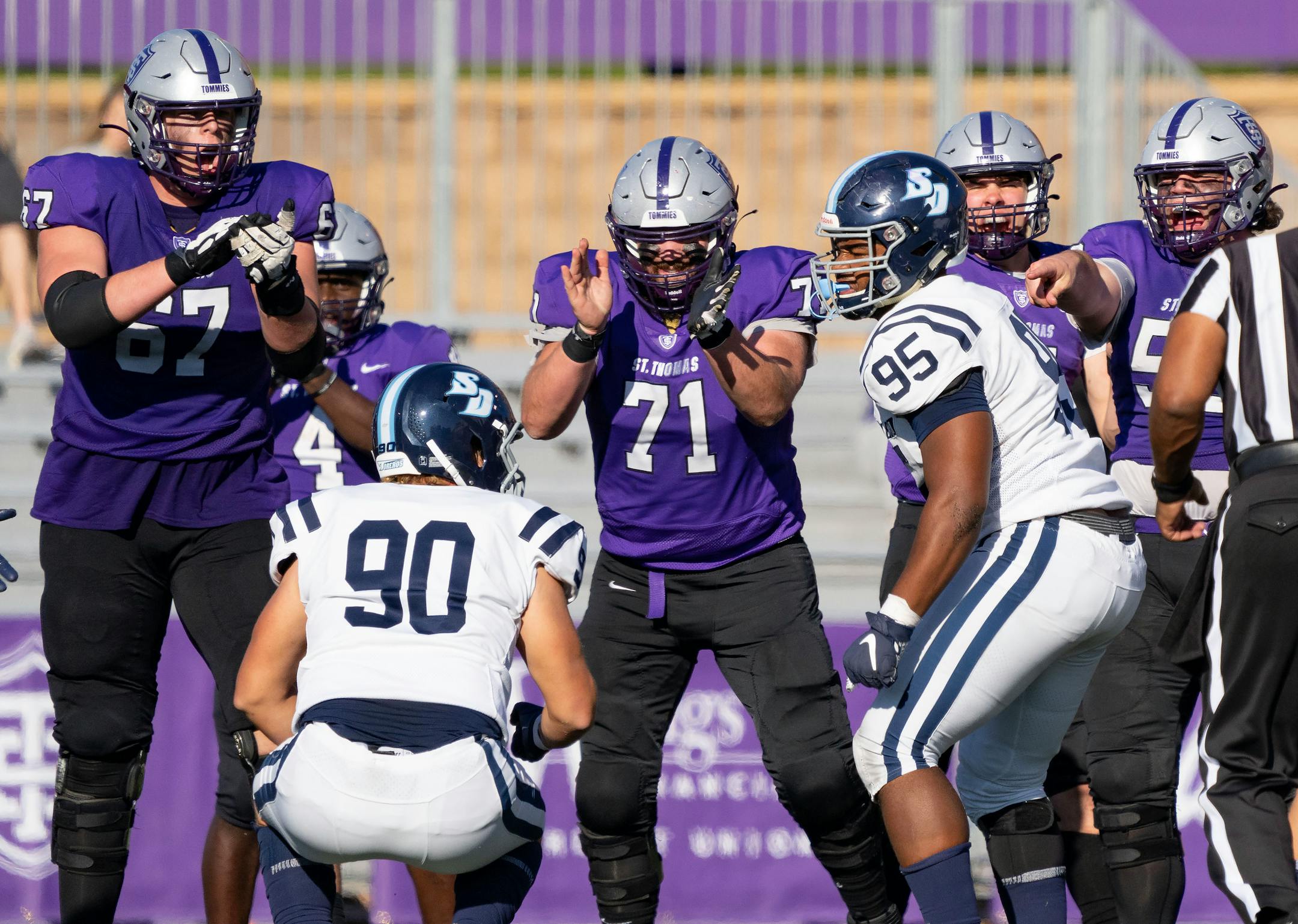 St. Thomas offensive linemen celebrate after San Diego Toreros defensive end Landon Colvin (90) jumped off sides granting the Tommies a first down.