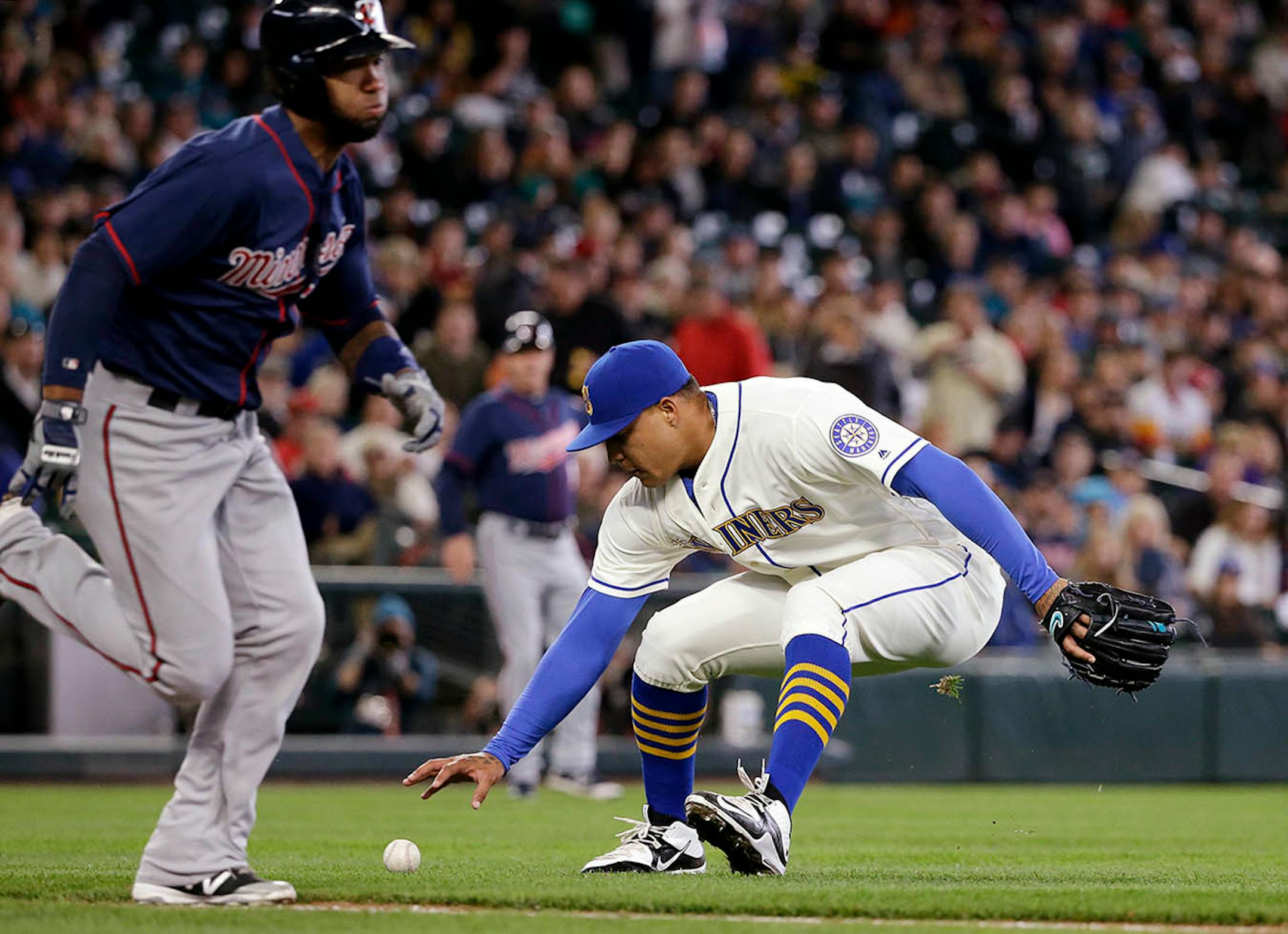 Minnesota Twins' Danny Santana, left, races to first as Seattle Mariners starting pitcher Taijuan Walker fields Santana's grounder in the fourth inning of a baseball game, Sunday, May 29, 2016, in Seattle. Walker threw Santana out on the play.