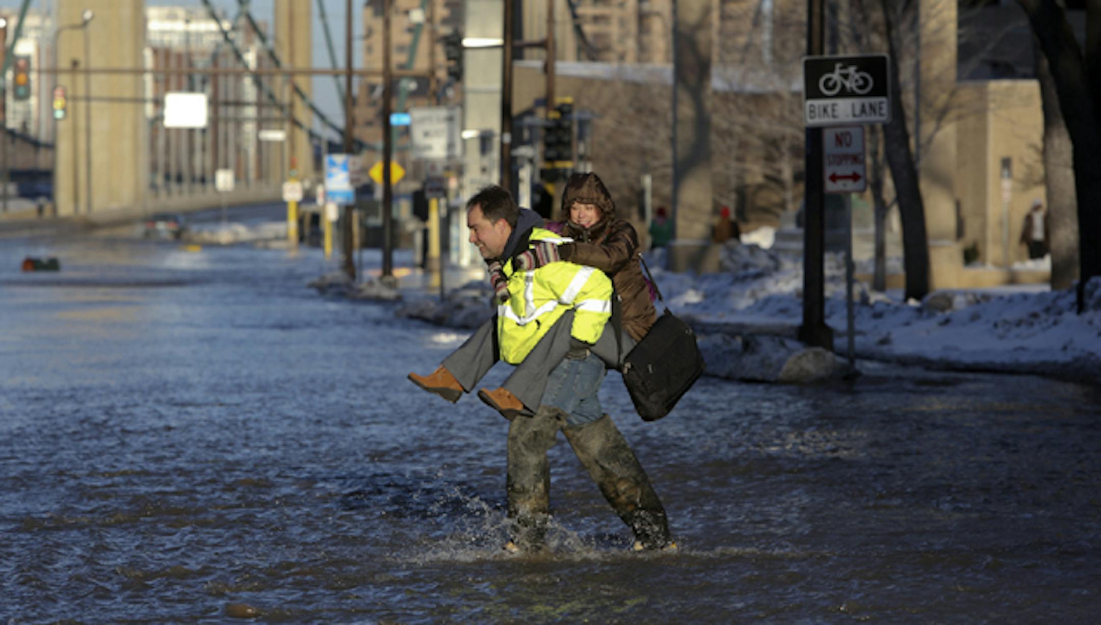 Worker Tim Green kept a Minneapolis pedestrian dry after a water main break Jan. 3 around Washington and Hennepin Avenues, near the U.S. post office.