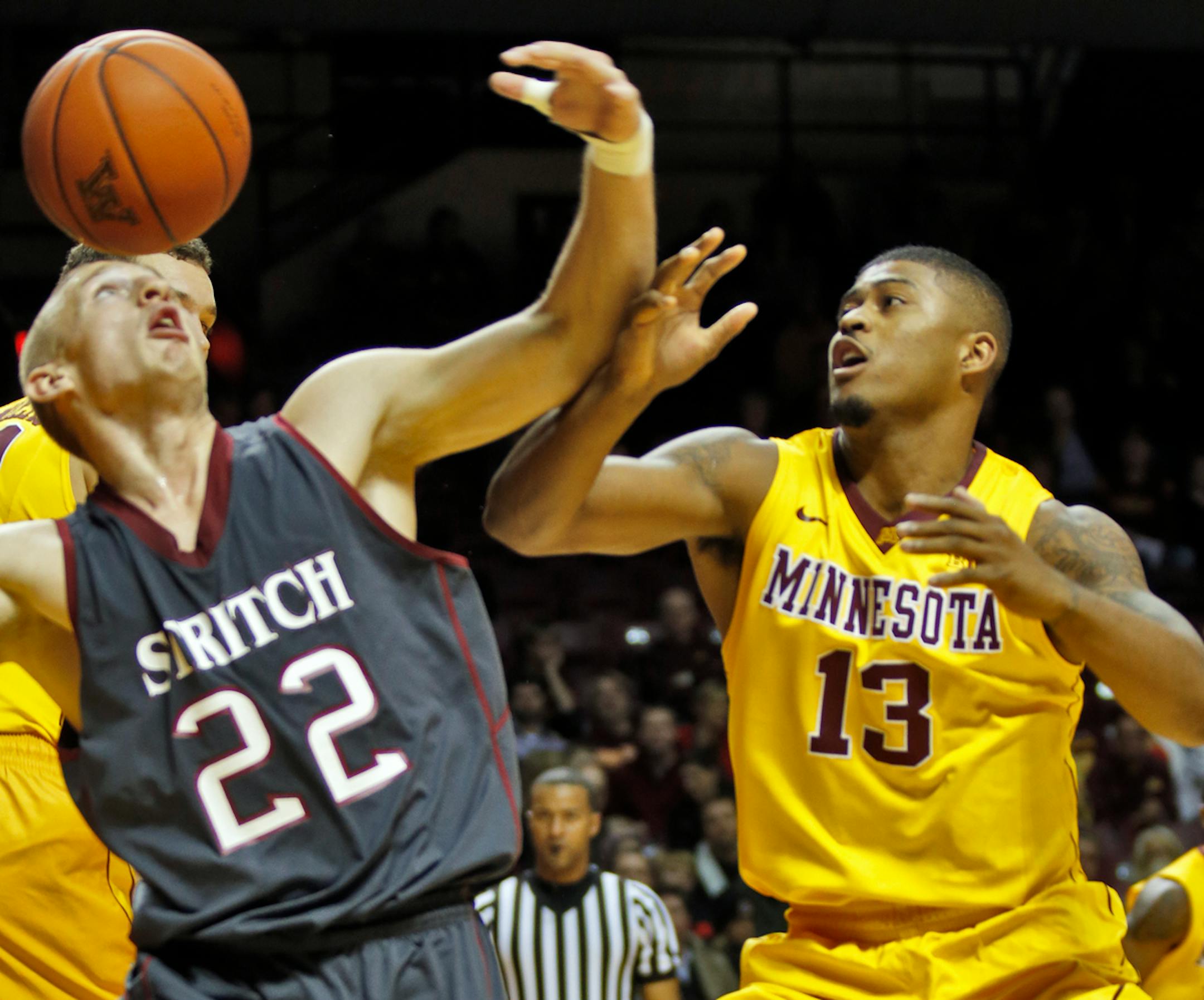 Cardinal Stritch player Tony Smit (22) had the defensive pressure applied by Minnesota's Maverick Ahanmisi.