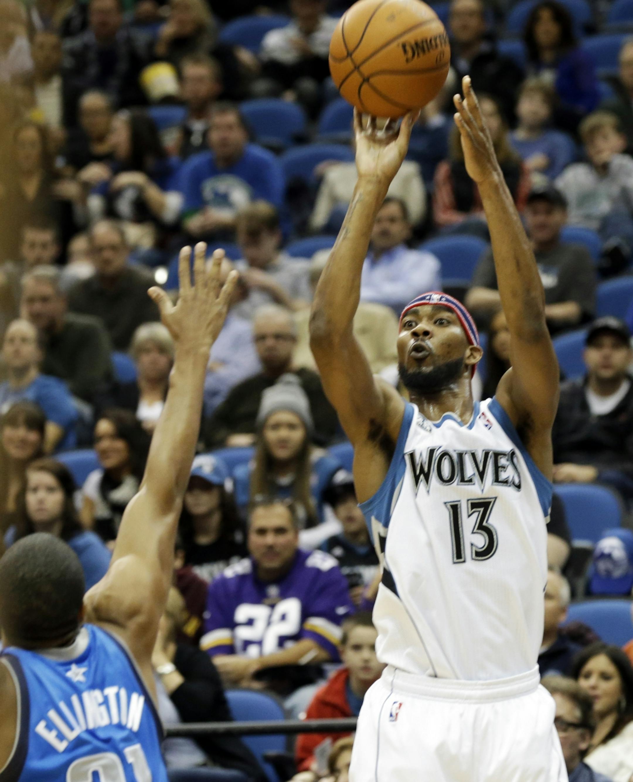 Minnesota Timberwolves' Corey Brewer, right, shoots a successful three-point basket over Dallas Mavericks' Wayne Ellington in the first quarter of an NBA basketball game on Friday, Nov. 8, 2013, in Minneapolis.