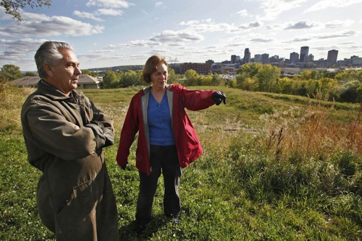 Long-time Railroad Island area residents Joe Garcia, left and Mary Brauer discussed the idea of townhomes being built on the Rivoli Bluff area that overlooks downtown St. Paul in the distance.