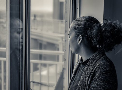 photo of author Quan Barry looking out of (and reflected in) a window