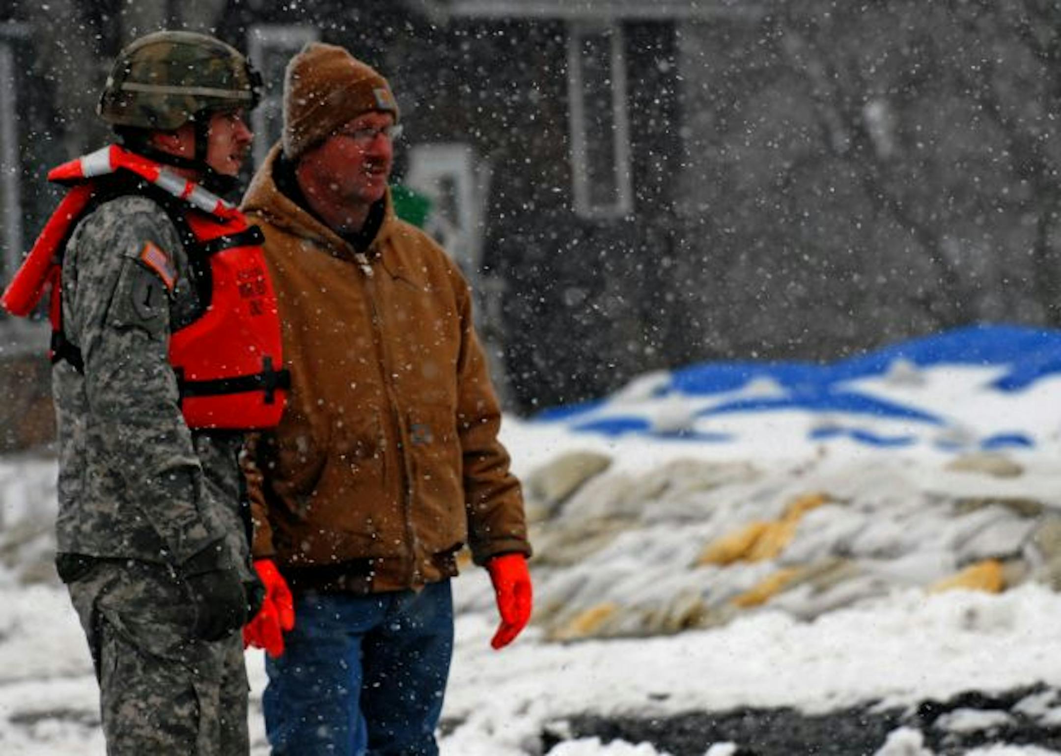 As Sgt. John Juracek of the Minnesota National Guard kept watch on a north Moorhead neighborhood, resident Craig Mazaur joined him to monitor a dike.