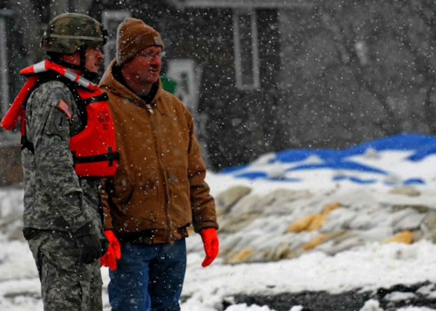 As Sgt. John Juracek of the Minnesota National Guard kept watch on a north Moorhead neighborhood, resident Craig Mazaur joined him to monitor a dike.