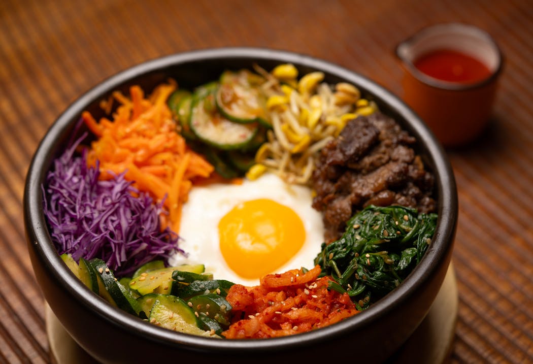 Kim's Stone Bowl Bibimbap, with short grain rice, bulgogi, marinated and pickled vegetables, sunny egg, and chojang, is a top-notch version of the Korean staple.