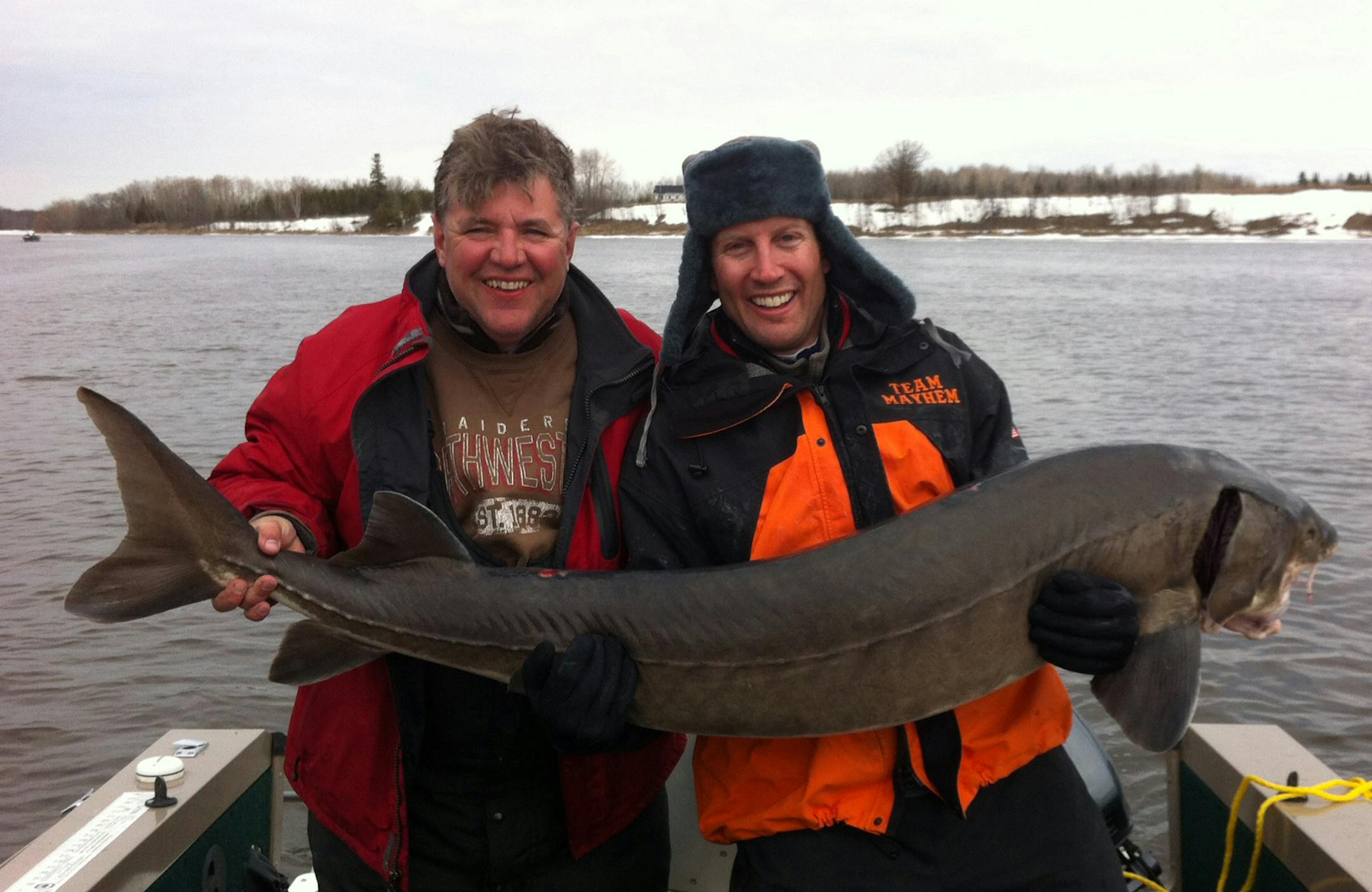 Andy Fronek, right, of Eden Prairie held the 71-inch monster sturgeon Fronek he caught on the Rainy River last weekend with the help of Patrick O’Kane of Maple Grove. “It had to be at least 100 pounds,’’ Fronek said.