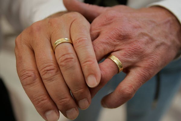 Don Ofstedal, right, and partner of 35 years Jerry Lee, right, from Minneapolis, Minn., show off their wedding rings to friends after getting married 