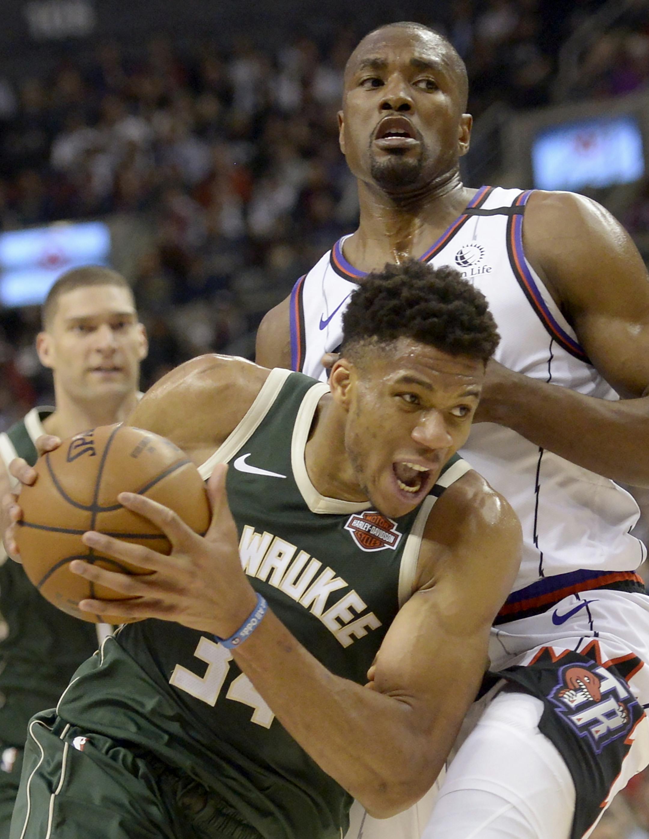 Milwaukee Bucks forward Giannis Antetokounmpo (34) drives past Toronto Raptors center Serge Ibaka (9) during the first half of an NBA basketball game Tuesday, Feb. 25, 2020, in Toronto. (Nathan Denette/The Canadian Press via AP)